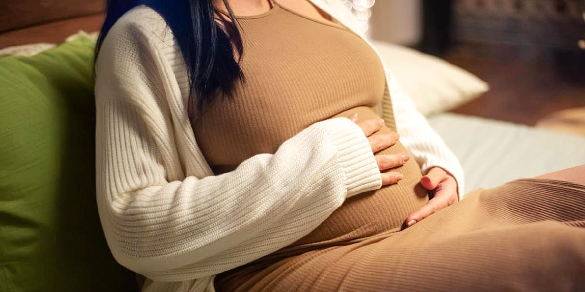 A pregnant woman cradling her belly | Source: Freepik
