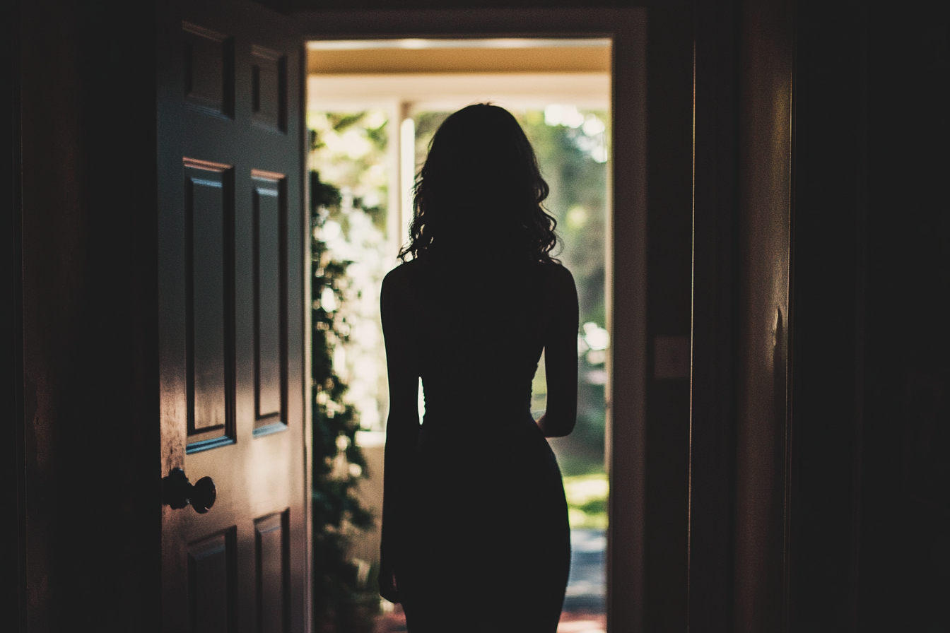 A woman silhouetted in a doorway | Source: No source