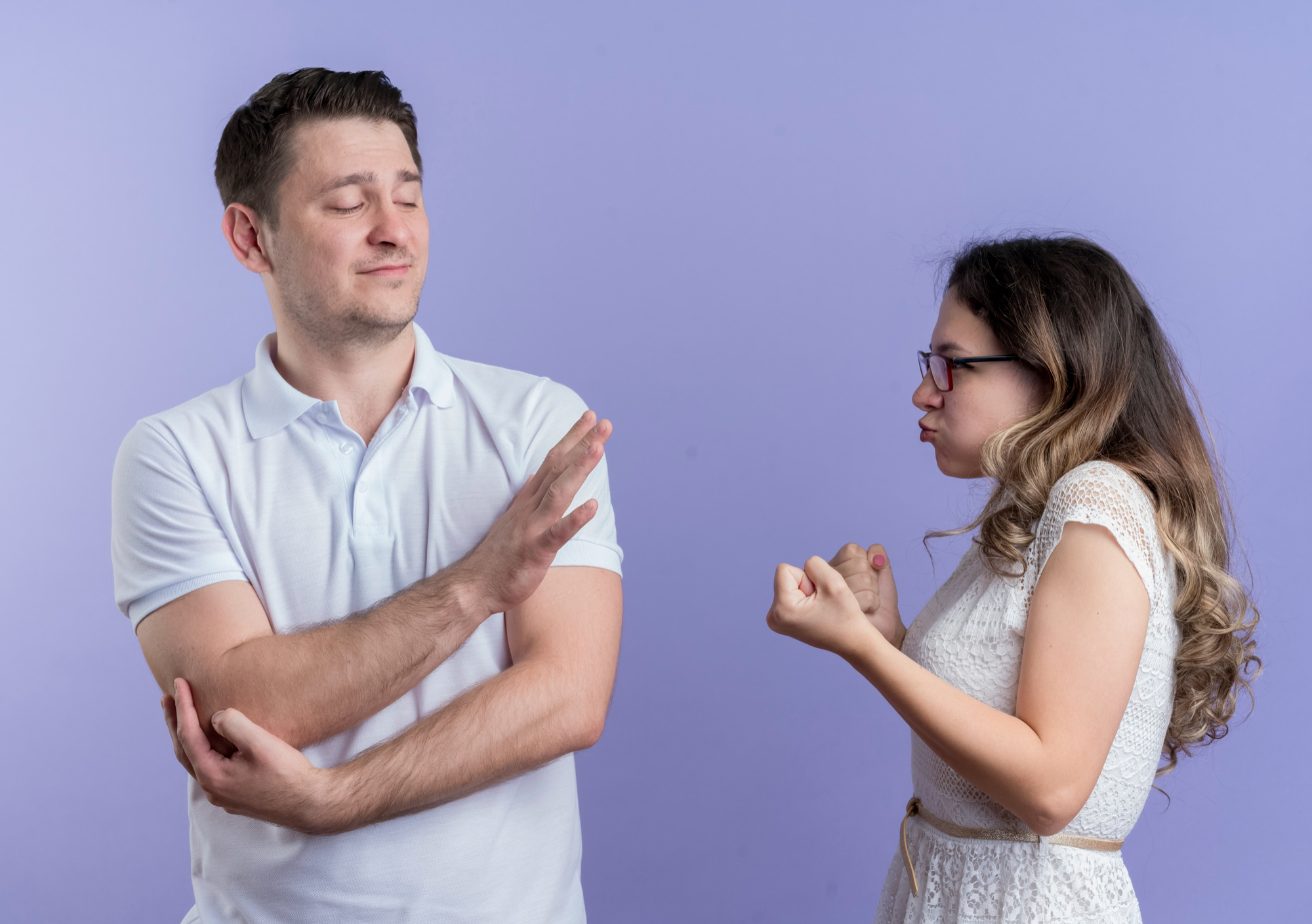 A frustrated woman with her hands in fists while standing next to an arrogant man | Source: Freepik