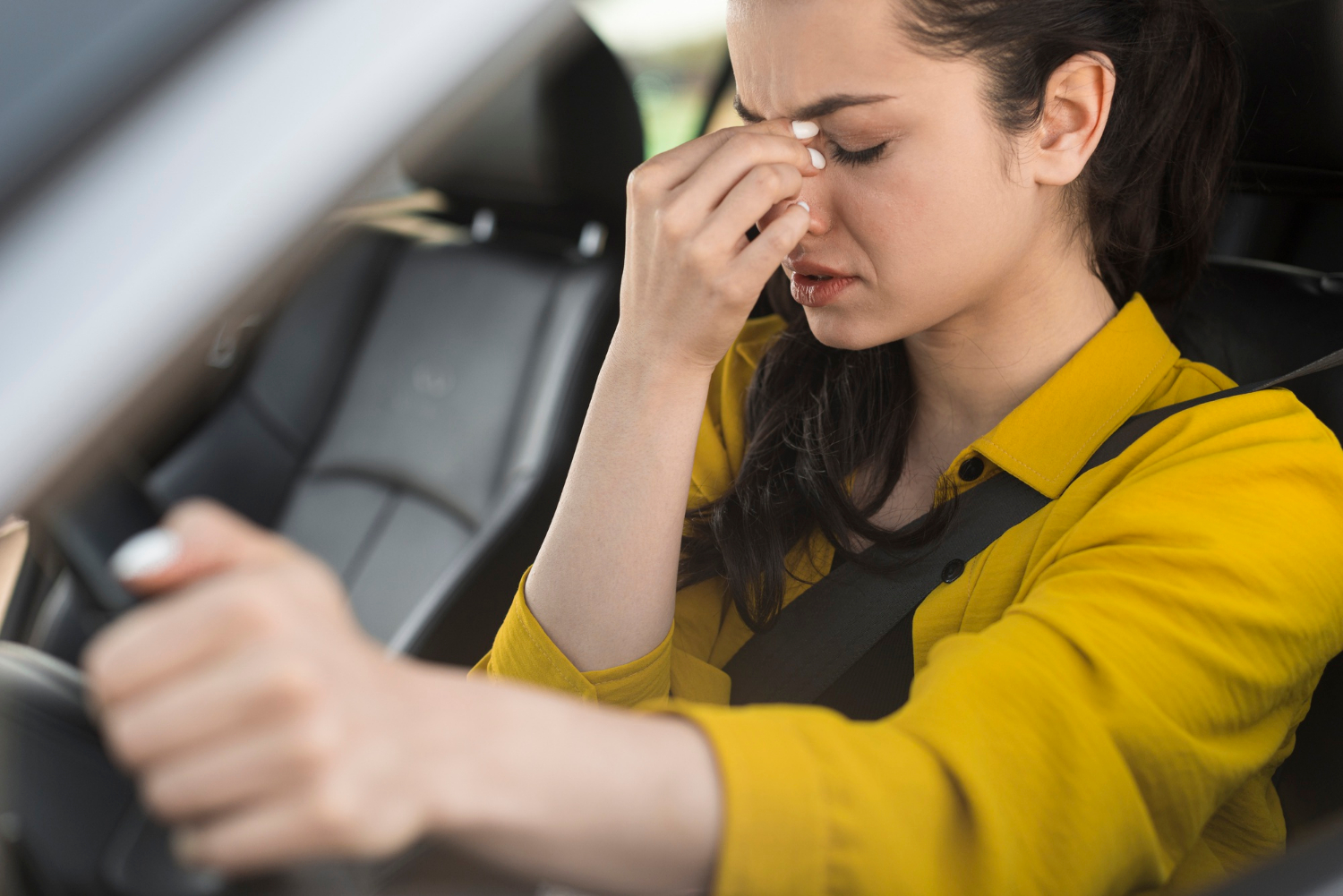 A tensed woman sitting behind the wheel of her vehicle | Source: Freepik