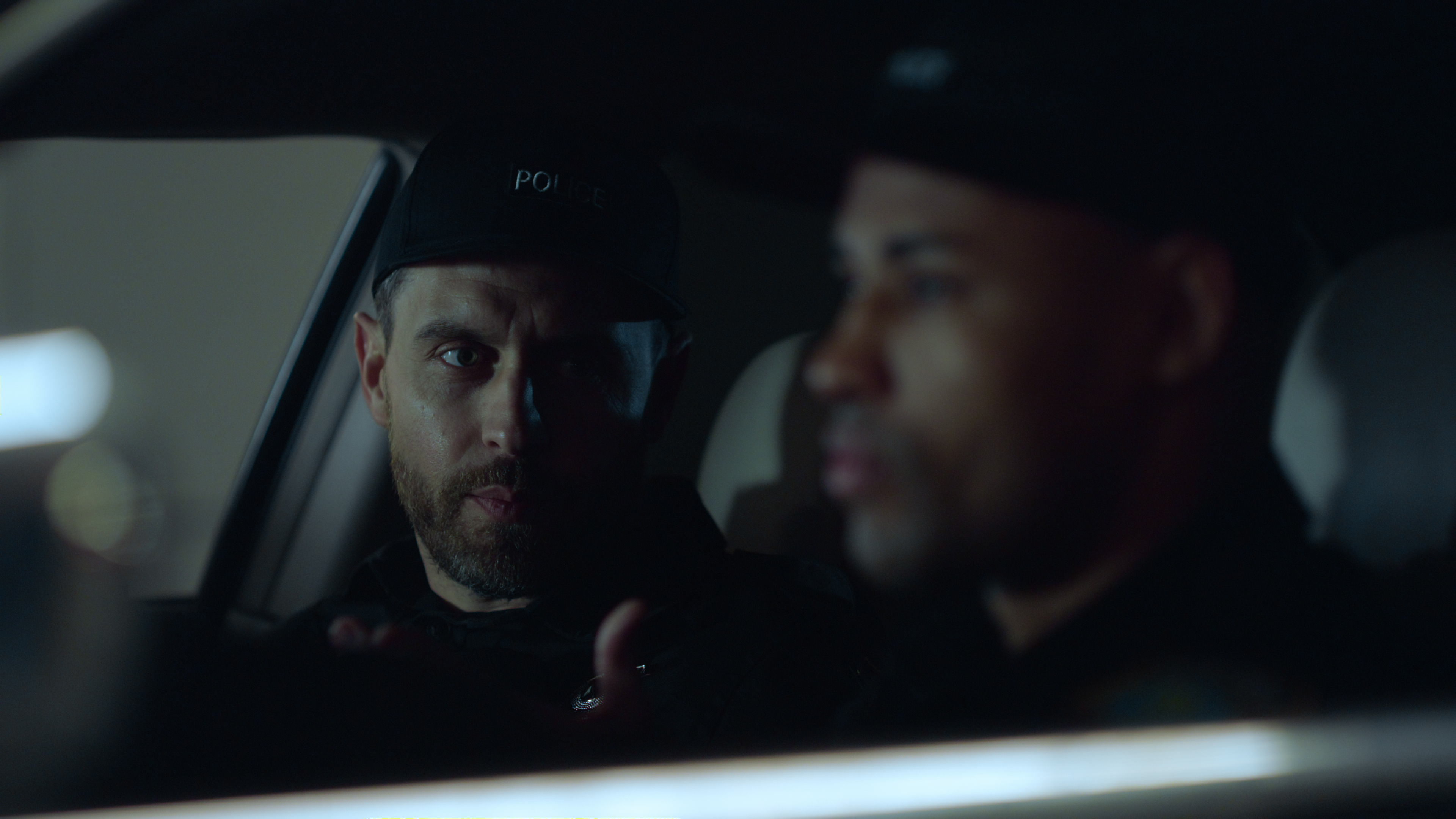 Portrait of male cops talking in police vehicle | Source: Shutterstock.com