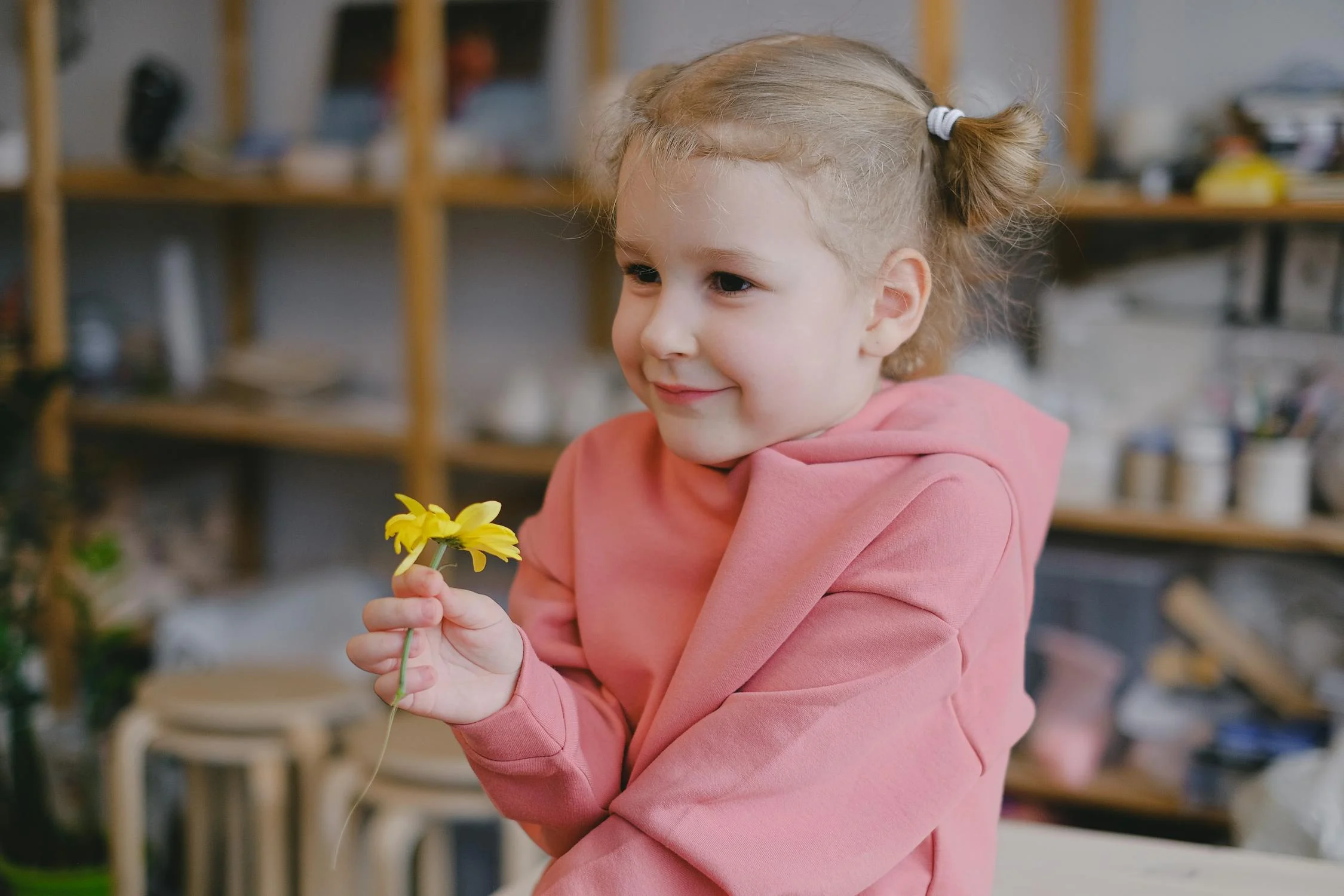 A small girl with a flower | Source: Pexels