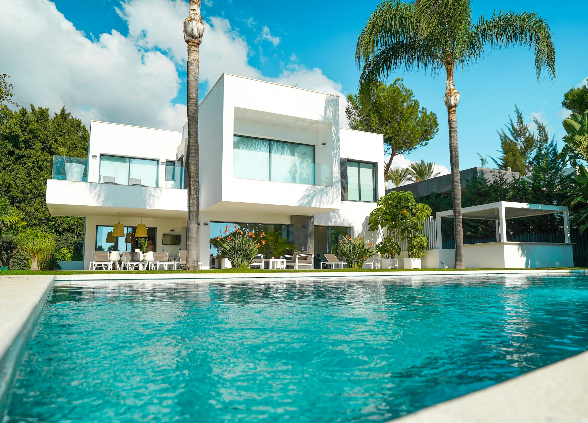 A modern villa with a swimming pool and sunlit garden | Source: Pexels