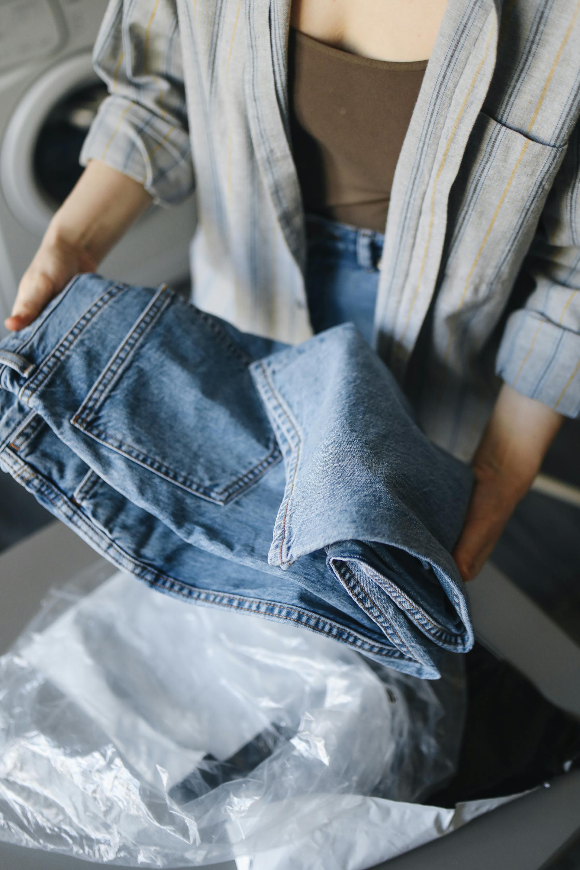 A close-up shot of a woman holding a pair of blue jeans | Source: Pexels