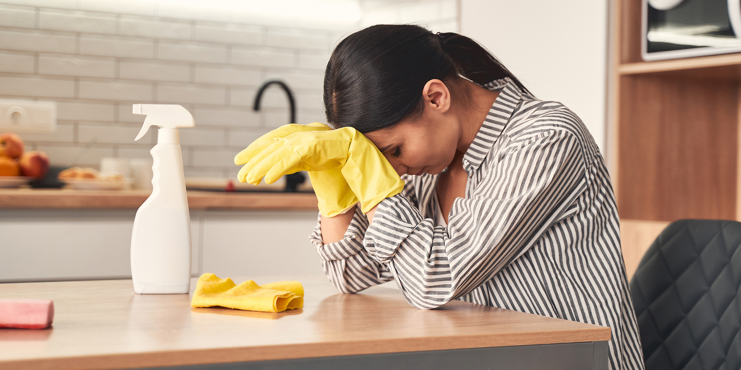 A woman sitting at a kitchen counter | Source: Shutterstock