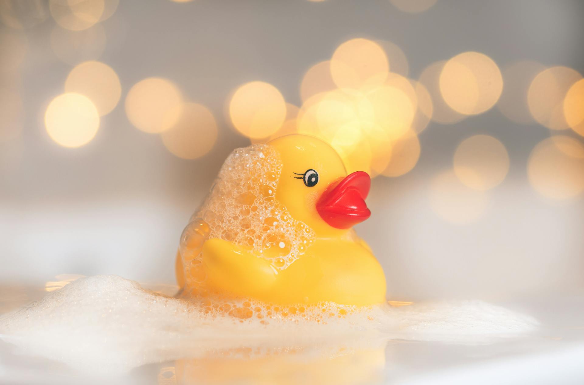 A rubber duck in soapy water | Source: Pexels