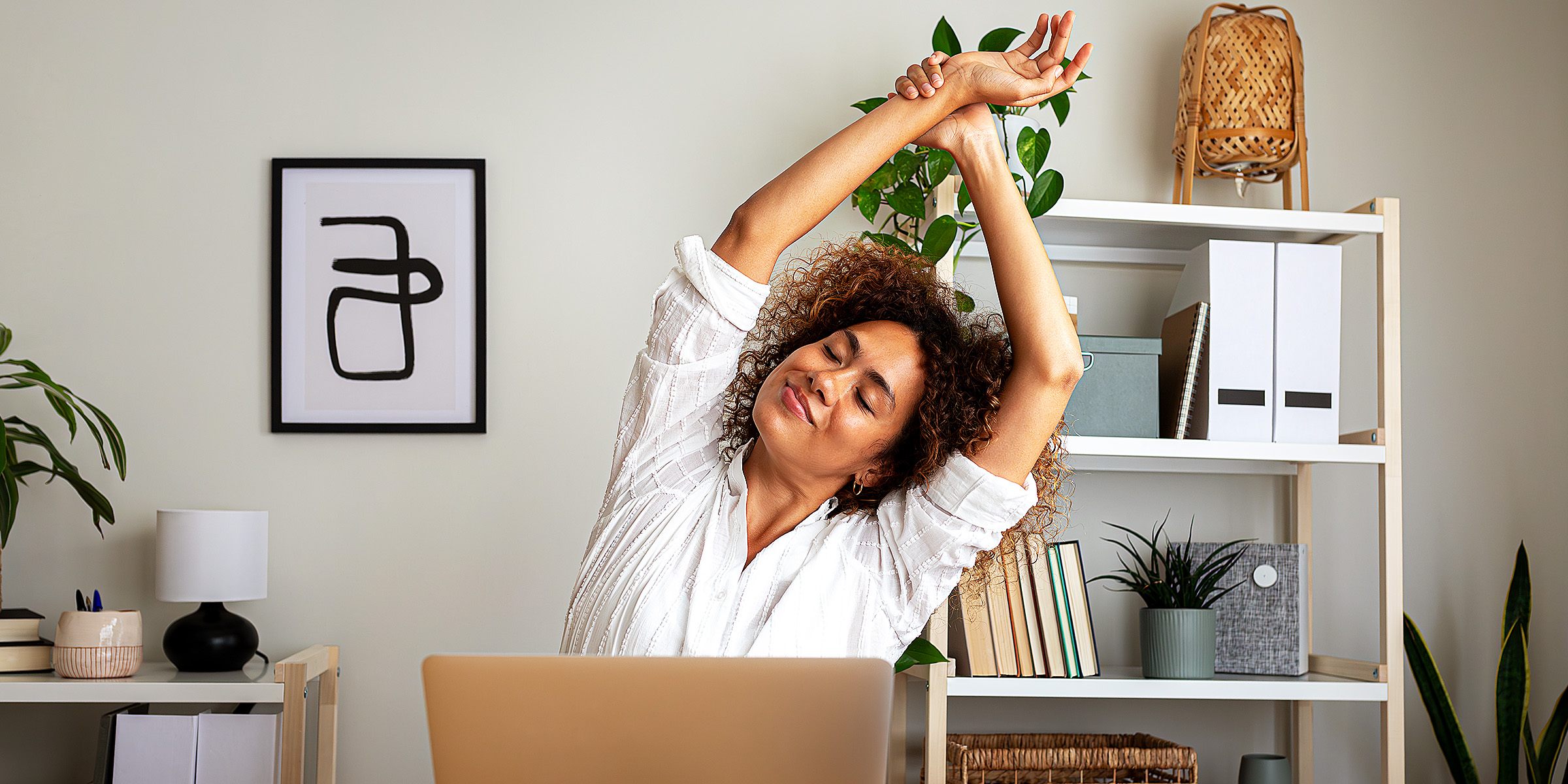 A woman stretching herself in her office | Source: Gett Images