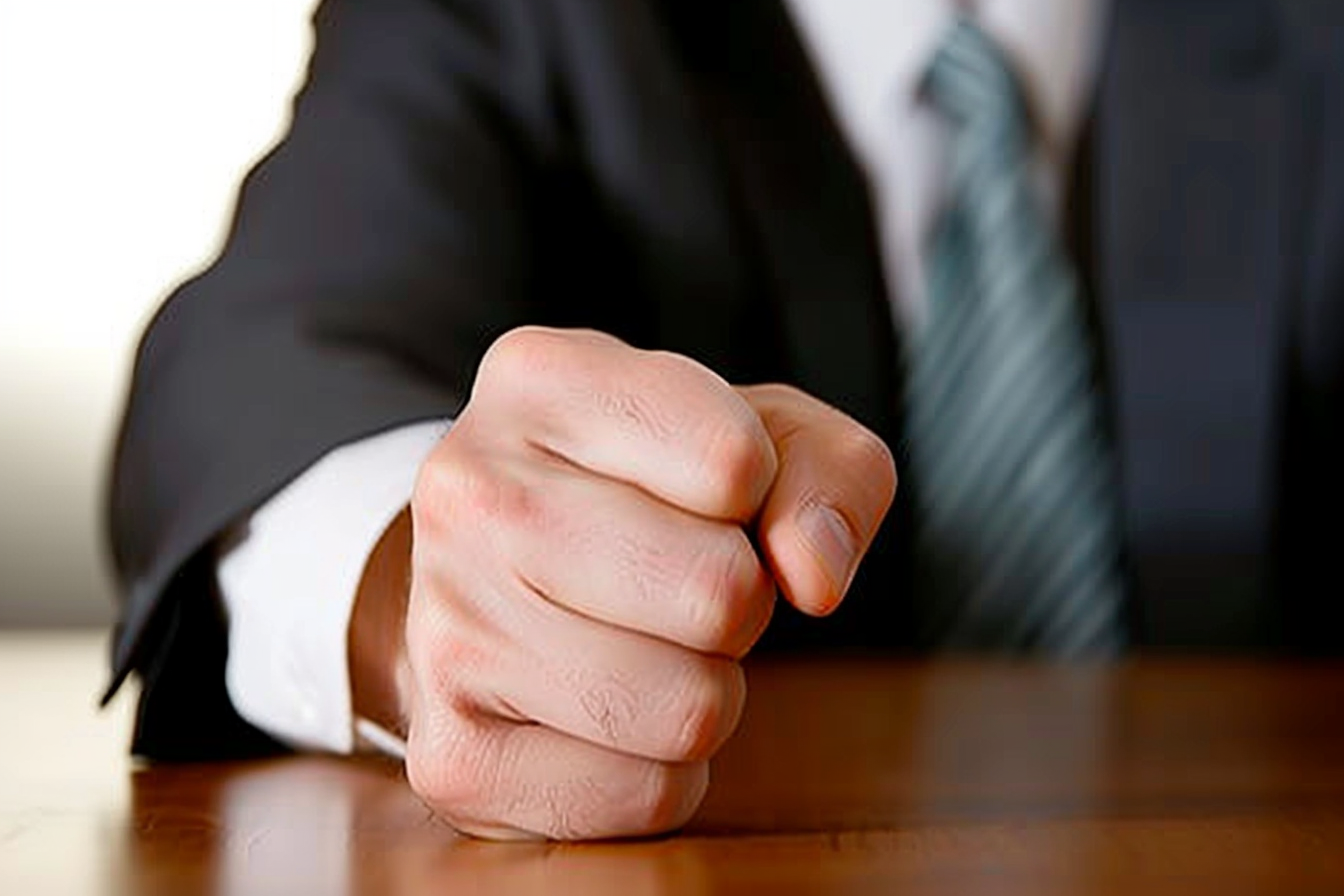 A close-up shot of a man's fist on a desk | Source: No source
