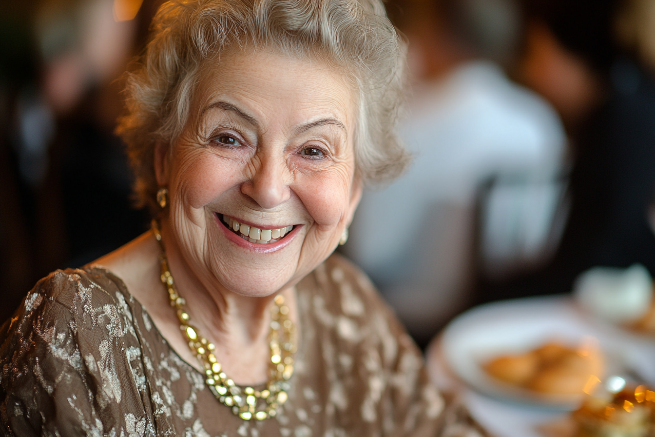 An elderly woman in a restaurant smiling at someone | Source: No source