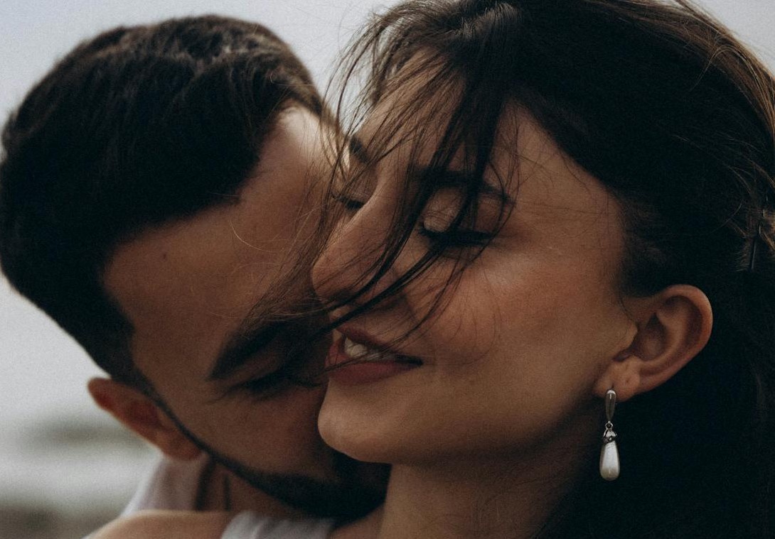 A man kissing a woman on her neck | Source: Pexels