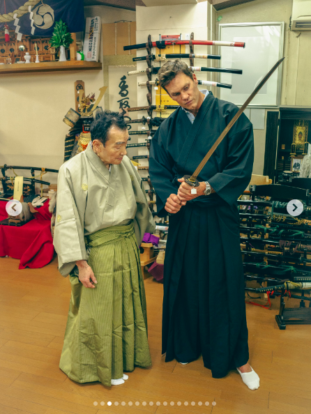Tom Brady wielding a sword with who appears to be a sword master standing next to him. | Source: Instagram/tombrady