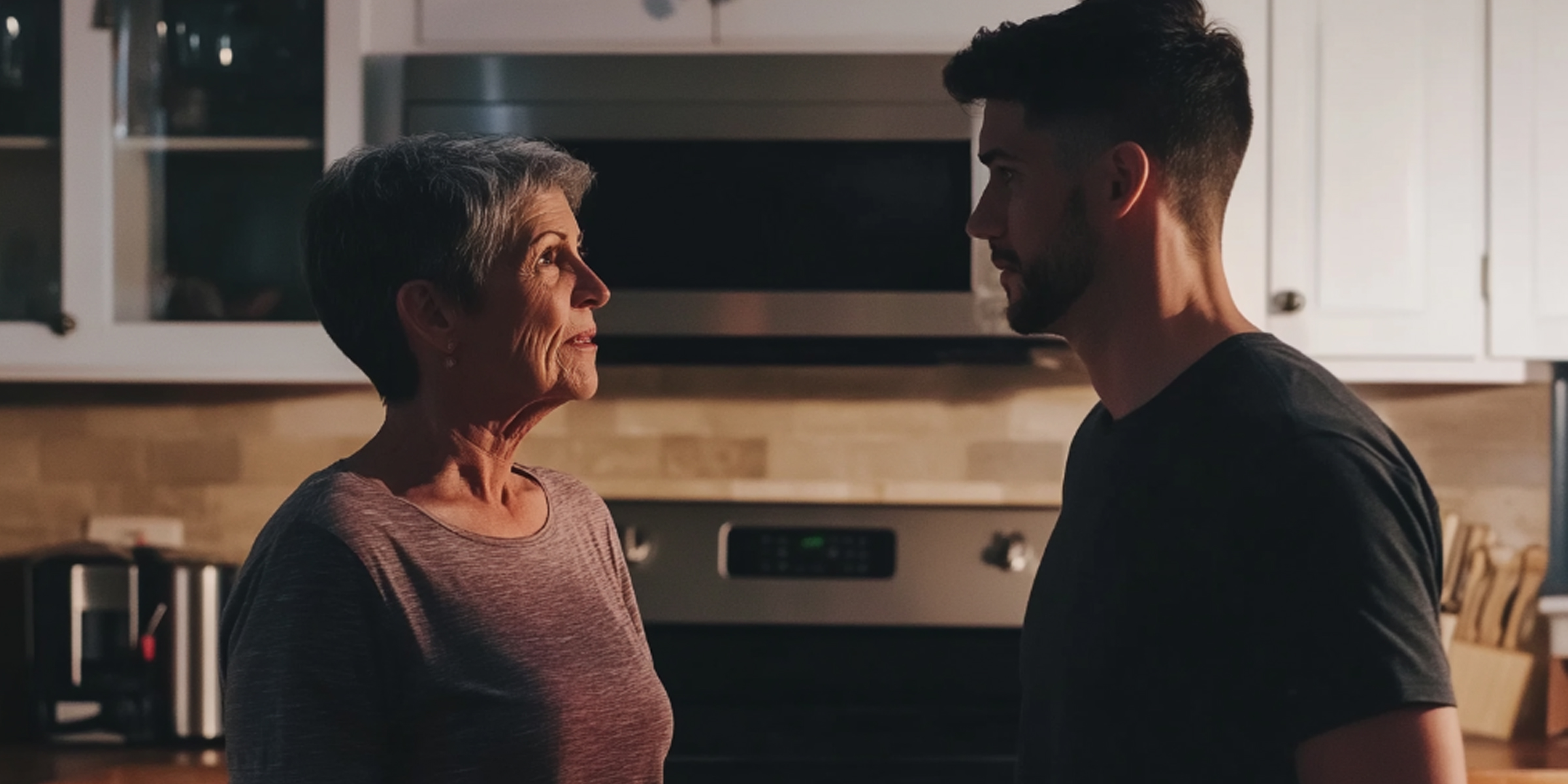 An older woman talking to a young man in the kitchen | Source: No source