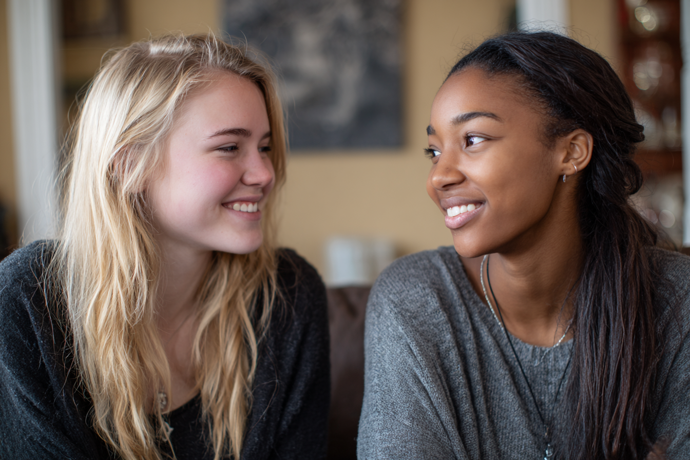 Two teen girls smiling at each other | Source: No source