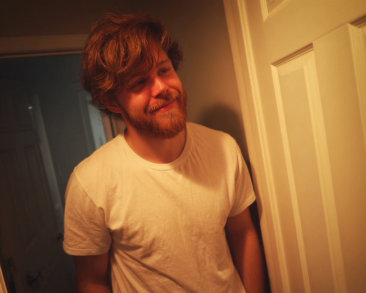 A smiling man standing in a doorway | Source: no source