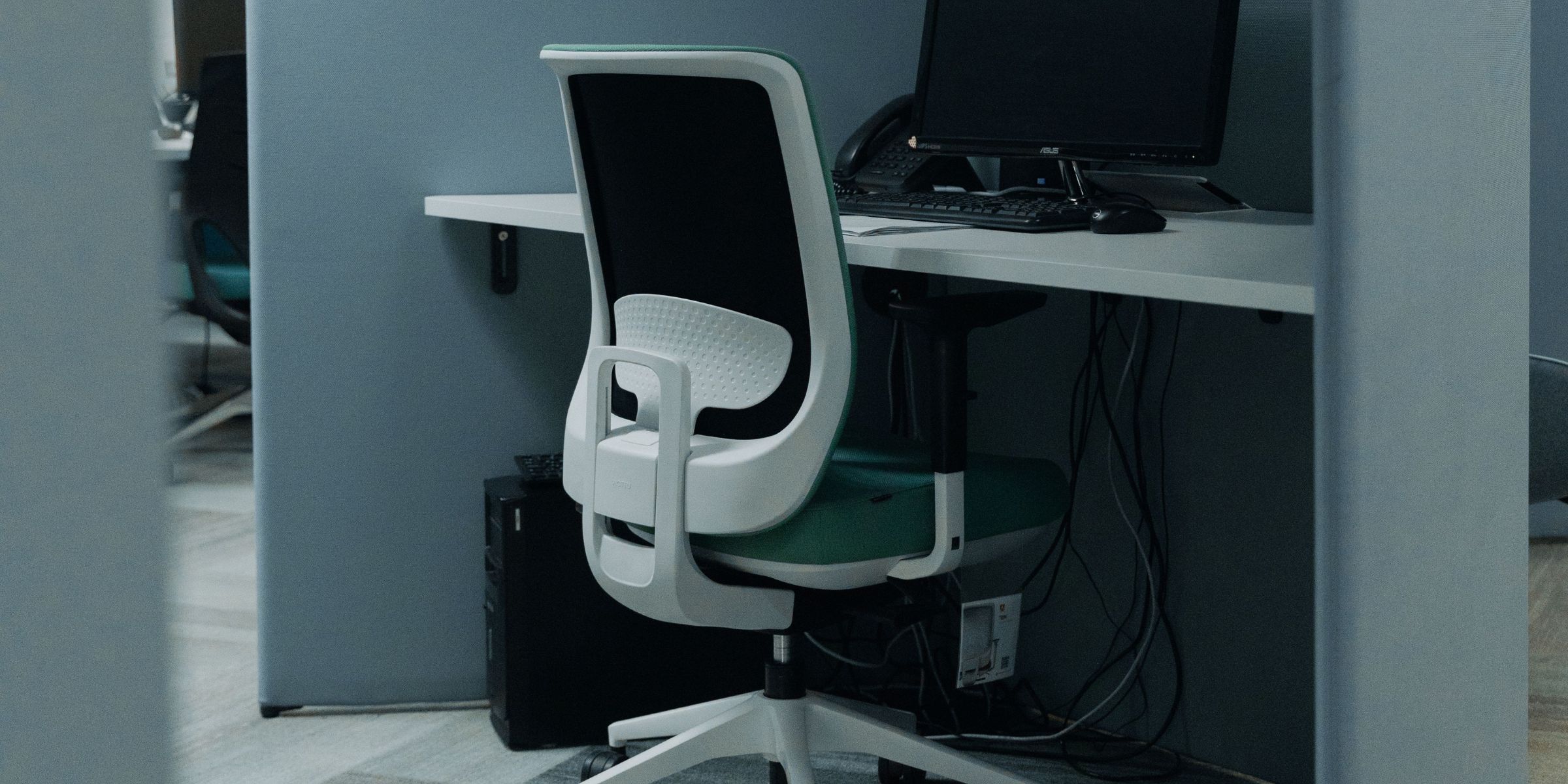 An office cubicle with a computer and a chair | Source: Pexels