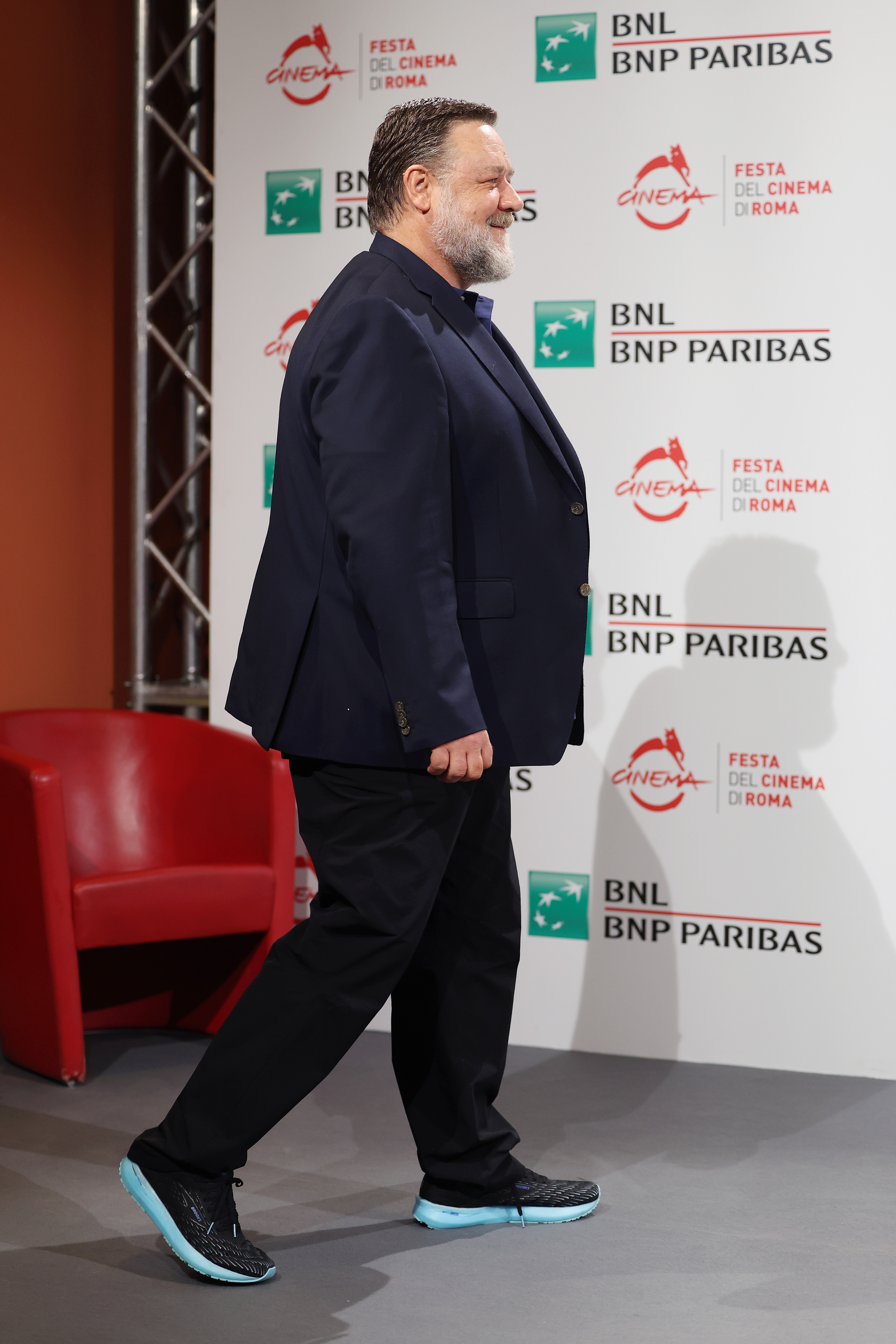 Russell Crowe stepped out for the "Poker Face" photocall during the 17th Rome Film Festival on October 16, 2022, in Italy, wearing a navy blazer and bright-soled sneakers. Flashing a smile as he walked, he appeared heavier set before he began the focused health regimen that would lead to a dramatic physical shift.