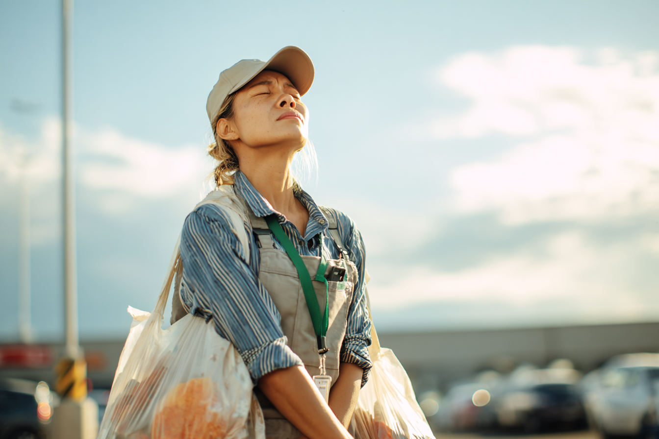A woman in a parking lot carrying bags of groceries | Source: No source