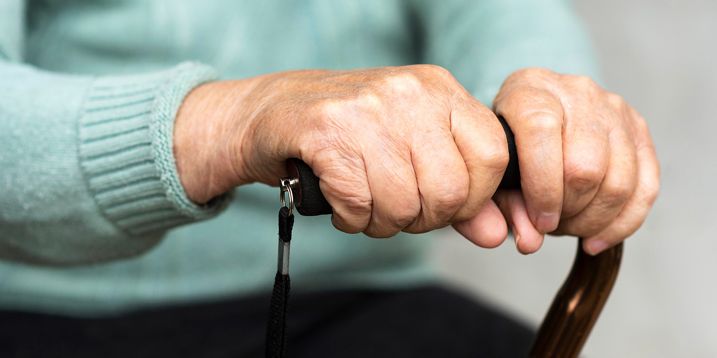 An old woman clutching a cane | Source: Freepik