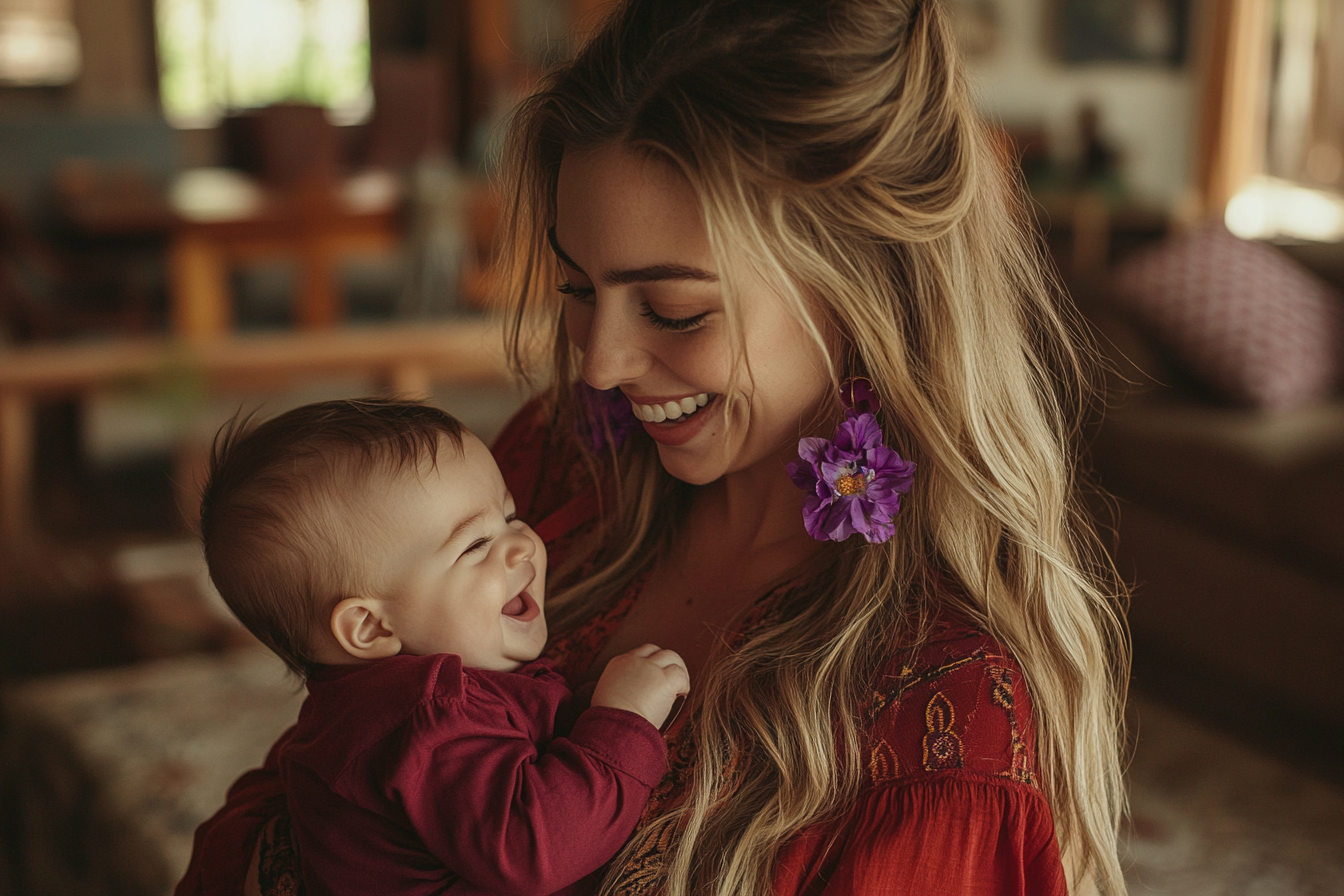 A woman smiling while holding a laughing baby | Source: No source