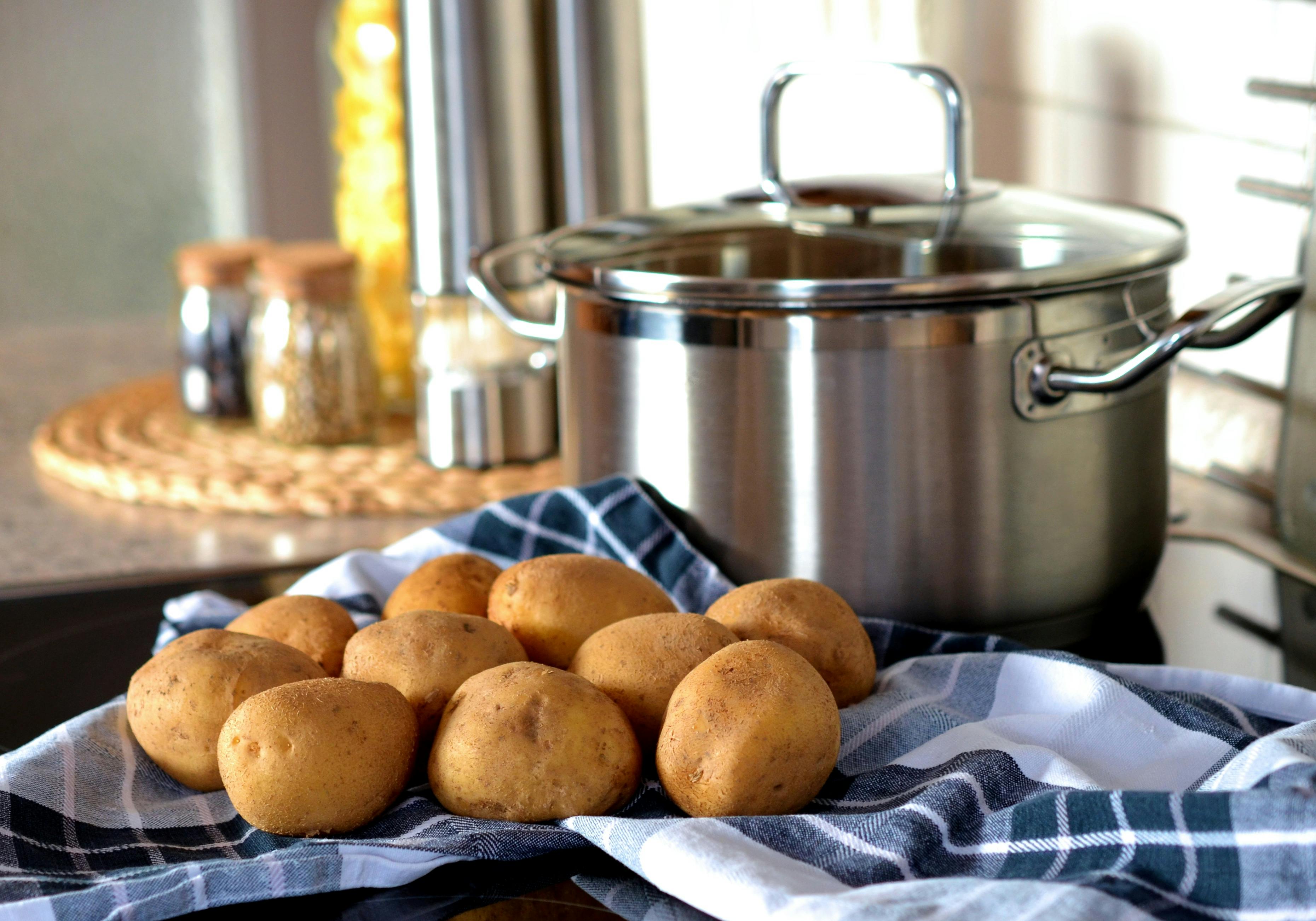 Potatoes next to a stainless steel pot | Source: Pexels