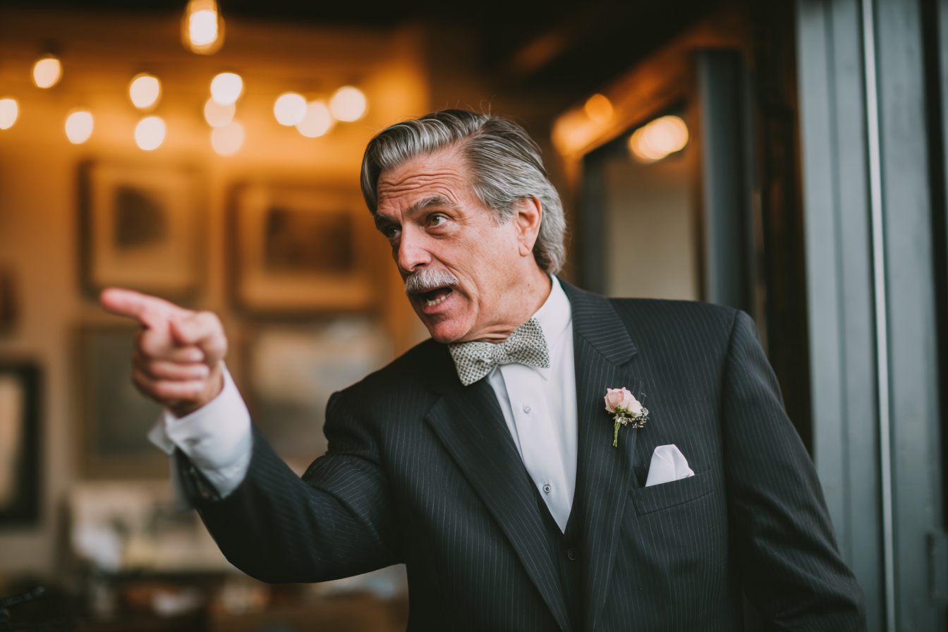 A man speaking sternly during a wedding reception | Source: no source