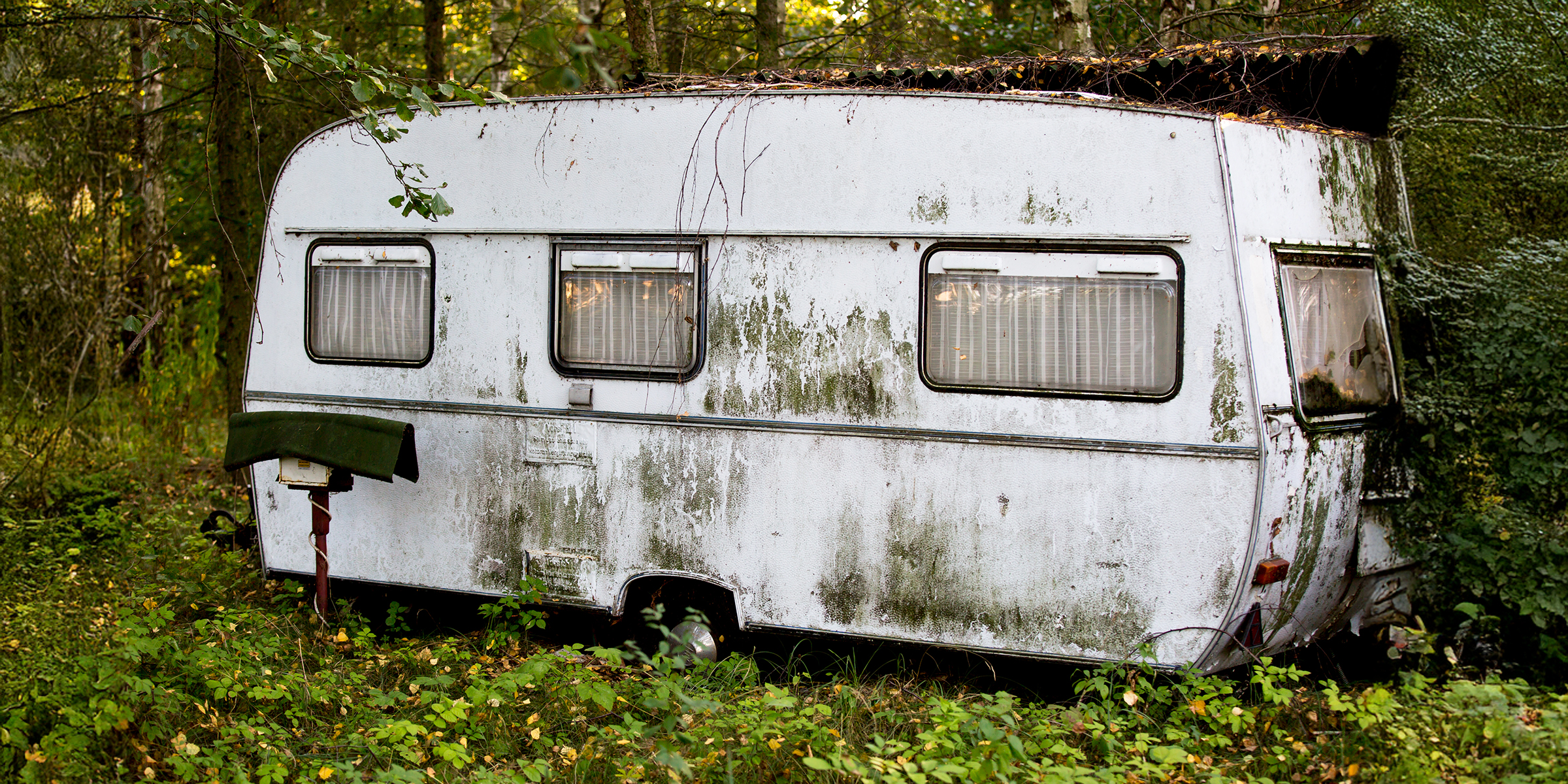 An old trailer in the woods | Source: No source