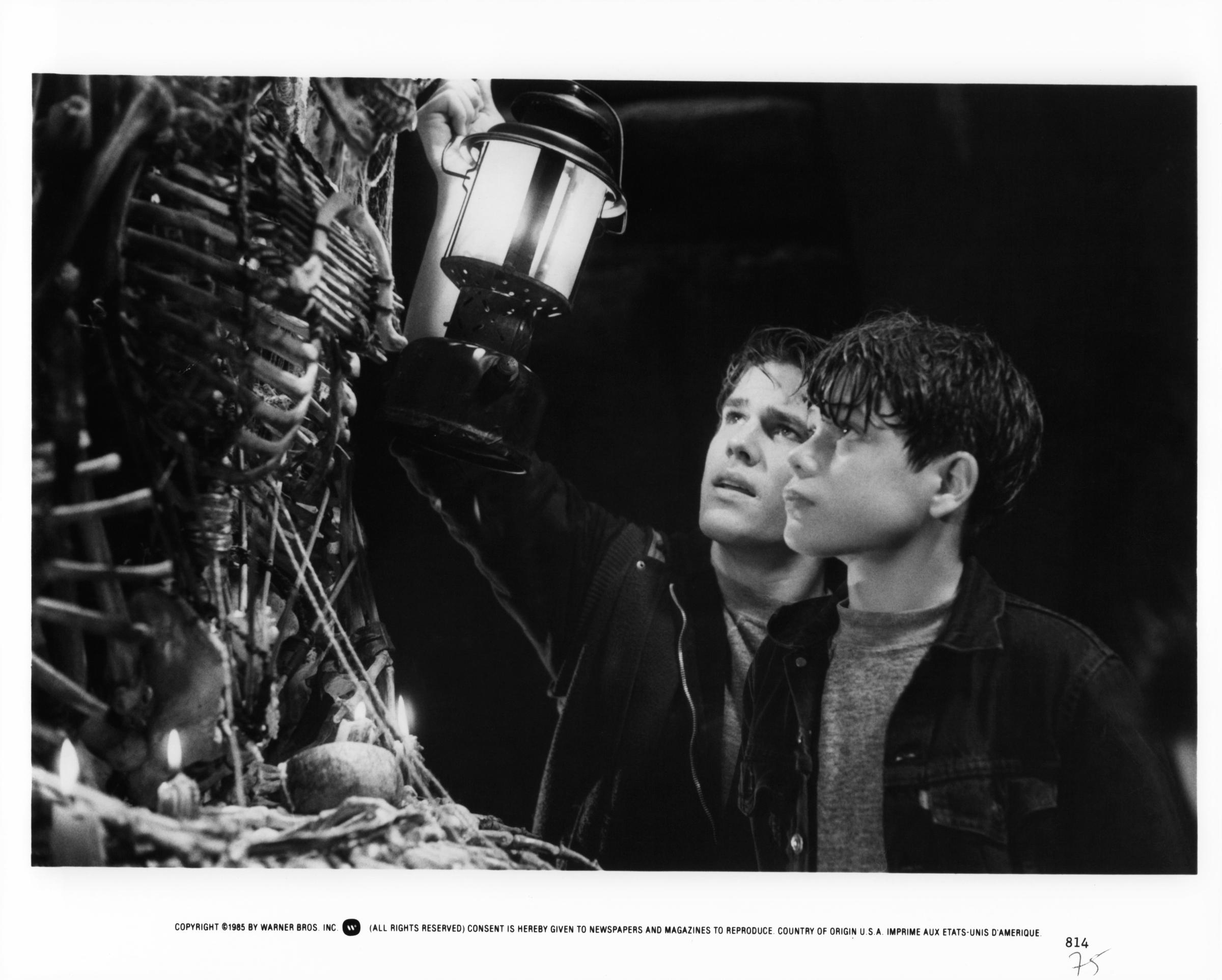 Josh Brolin and Sean Astin holding up light to bones in a scene from the film "Goonies," in 1985 | Source: Getty Images
