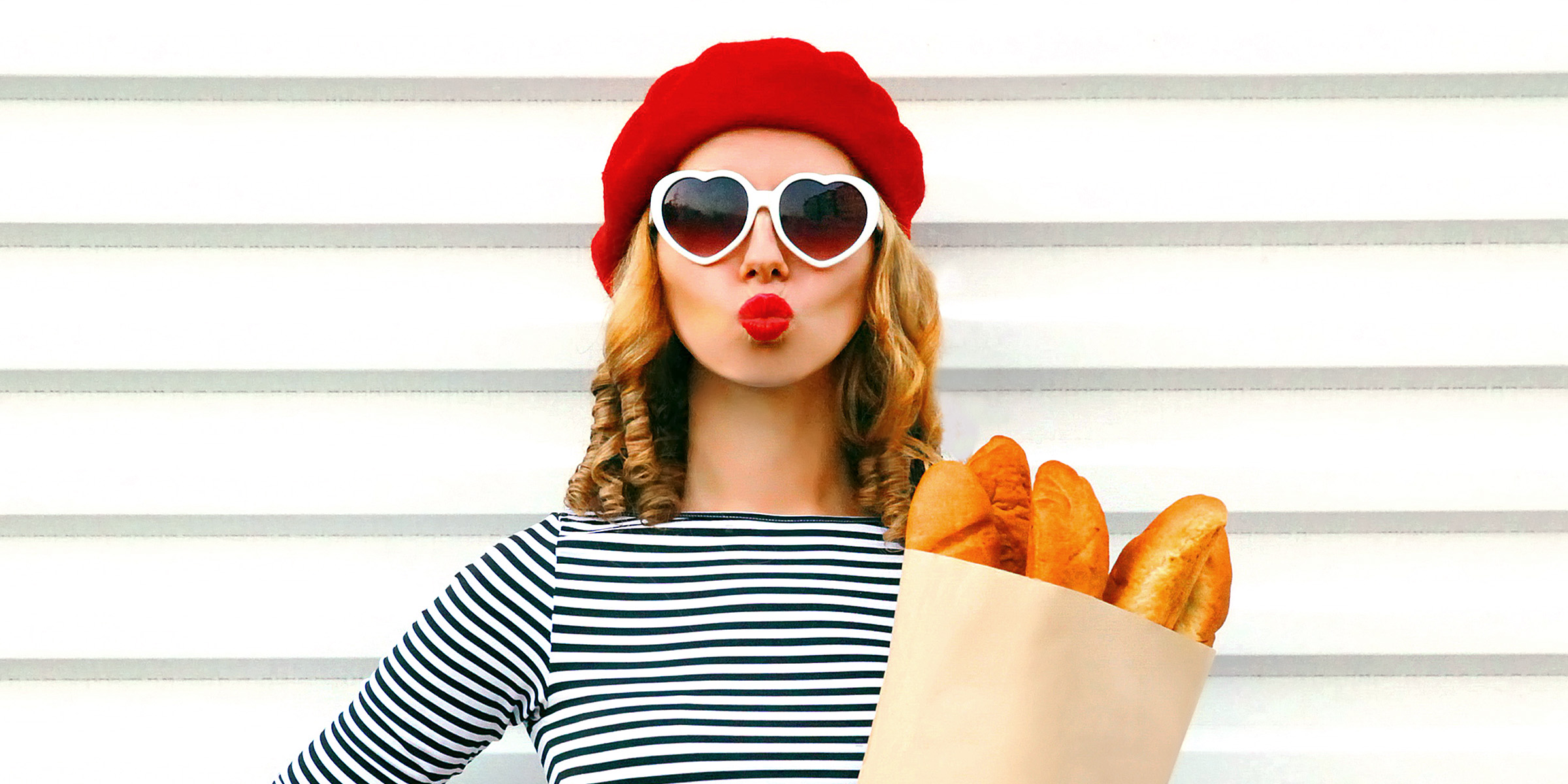 A woman holding a bag of baguettes | Source: Getty Images