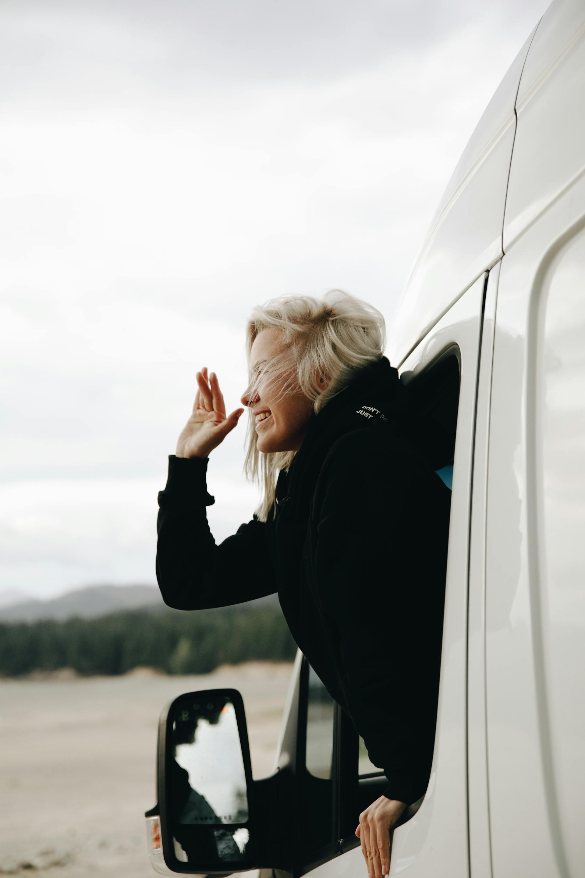A woman waving from a vehicle | Source: Pexels