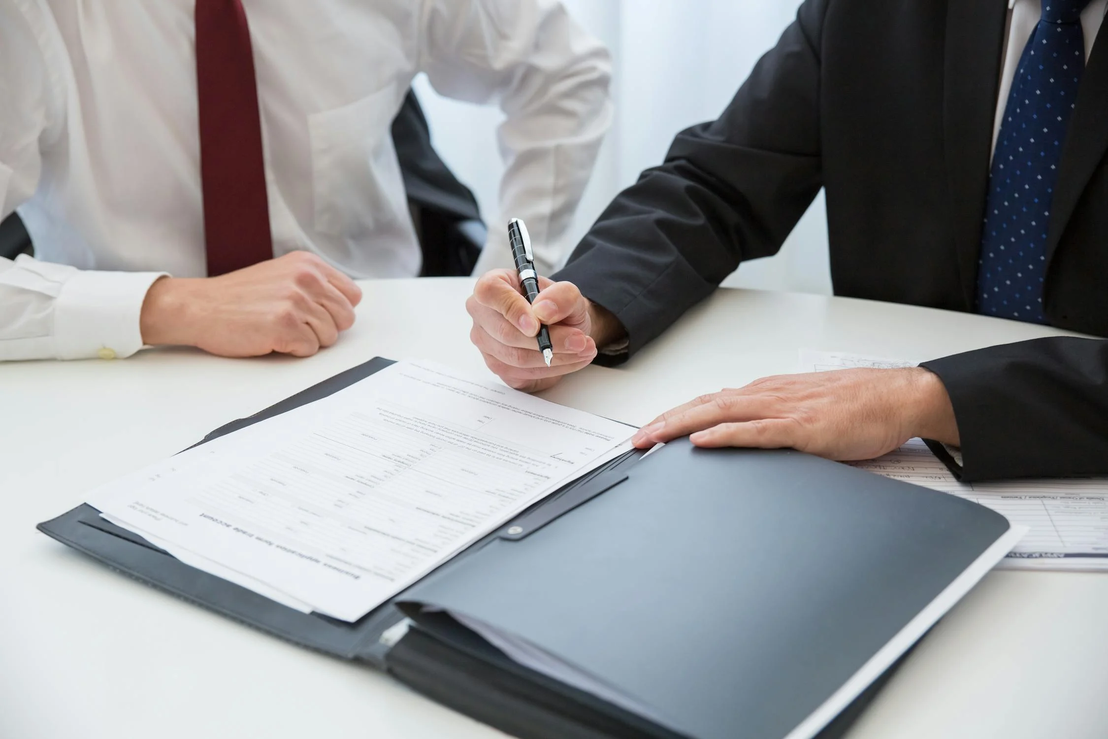 A man signing documents | Source: Pexels