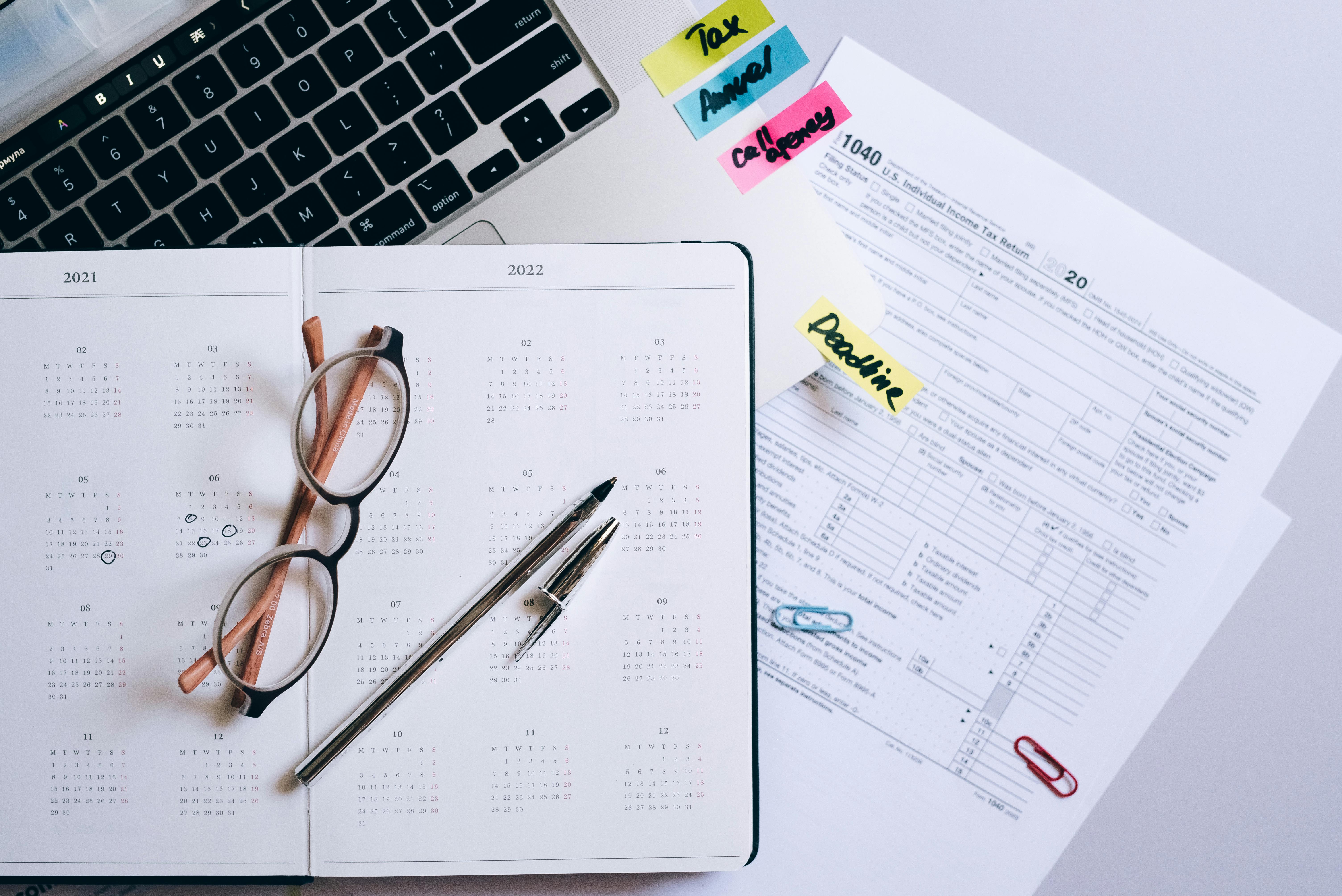 Calendar and tax documents on a desk | Source: Pexels