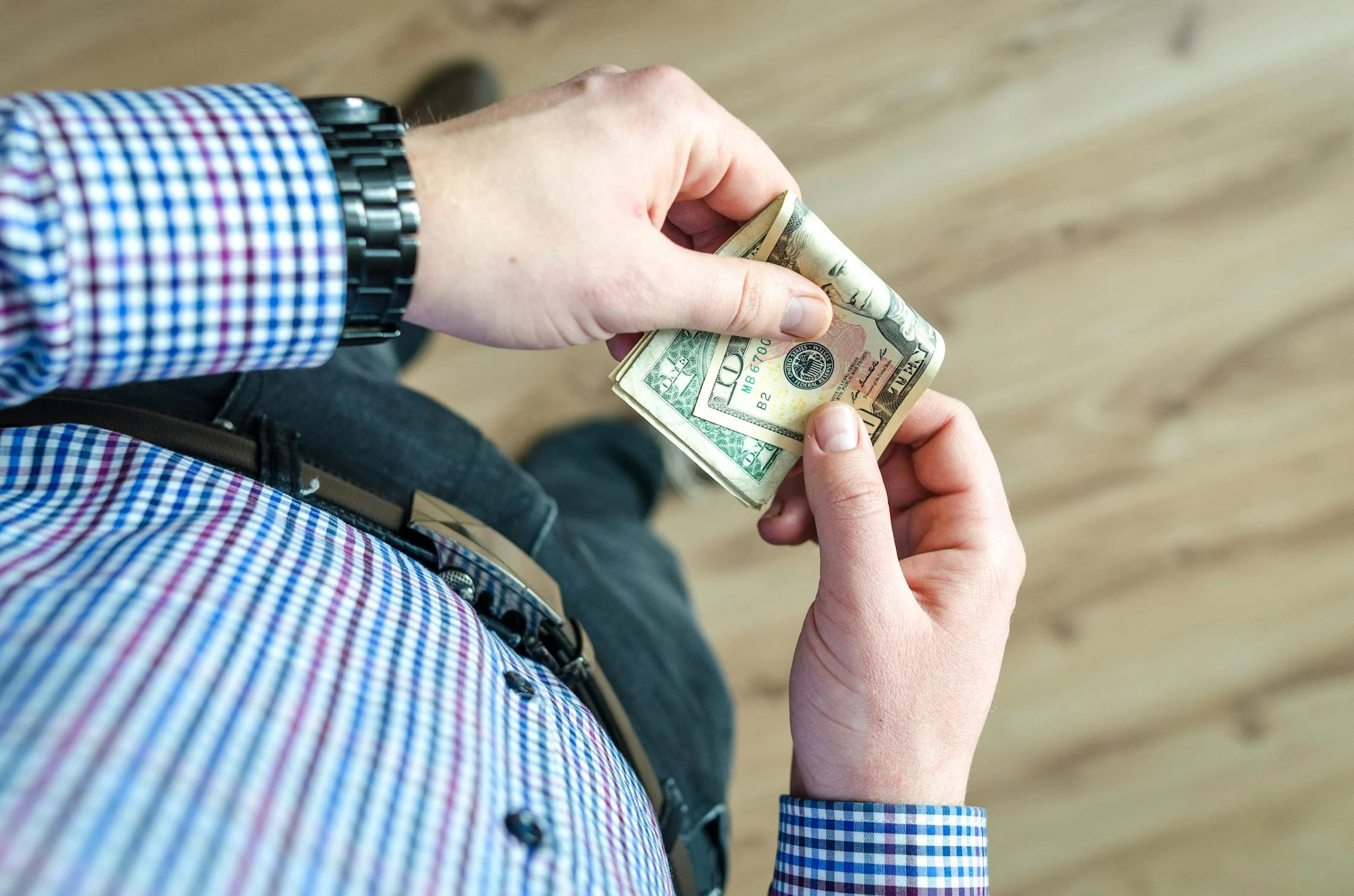 A man holding dollar bills | Source: Pexels