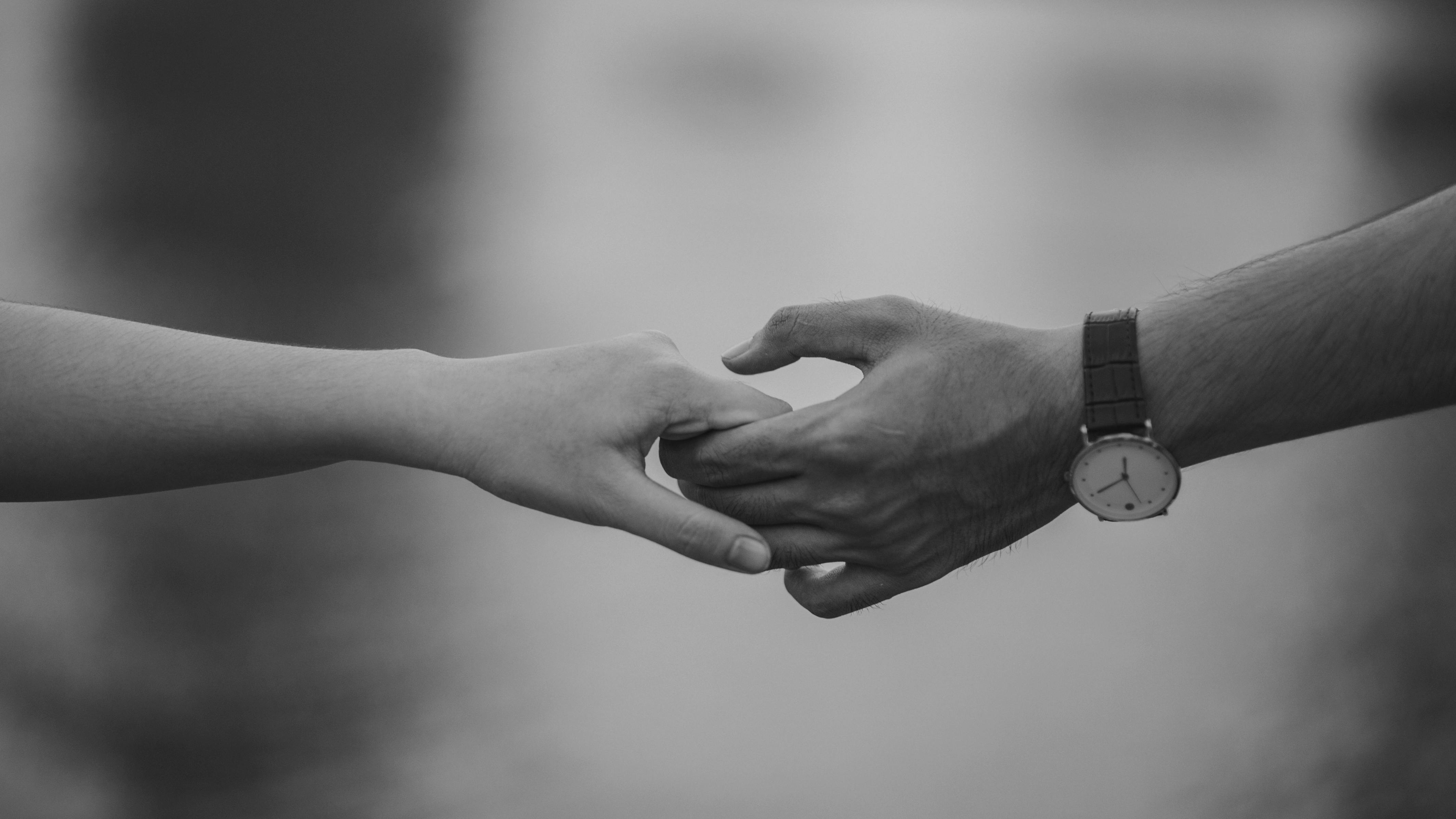 Monochrome photo of a couple holding hands | Source: Pexels