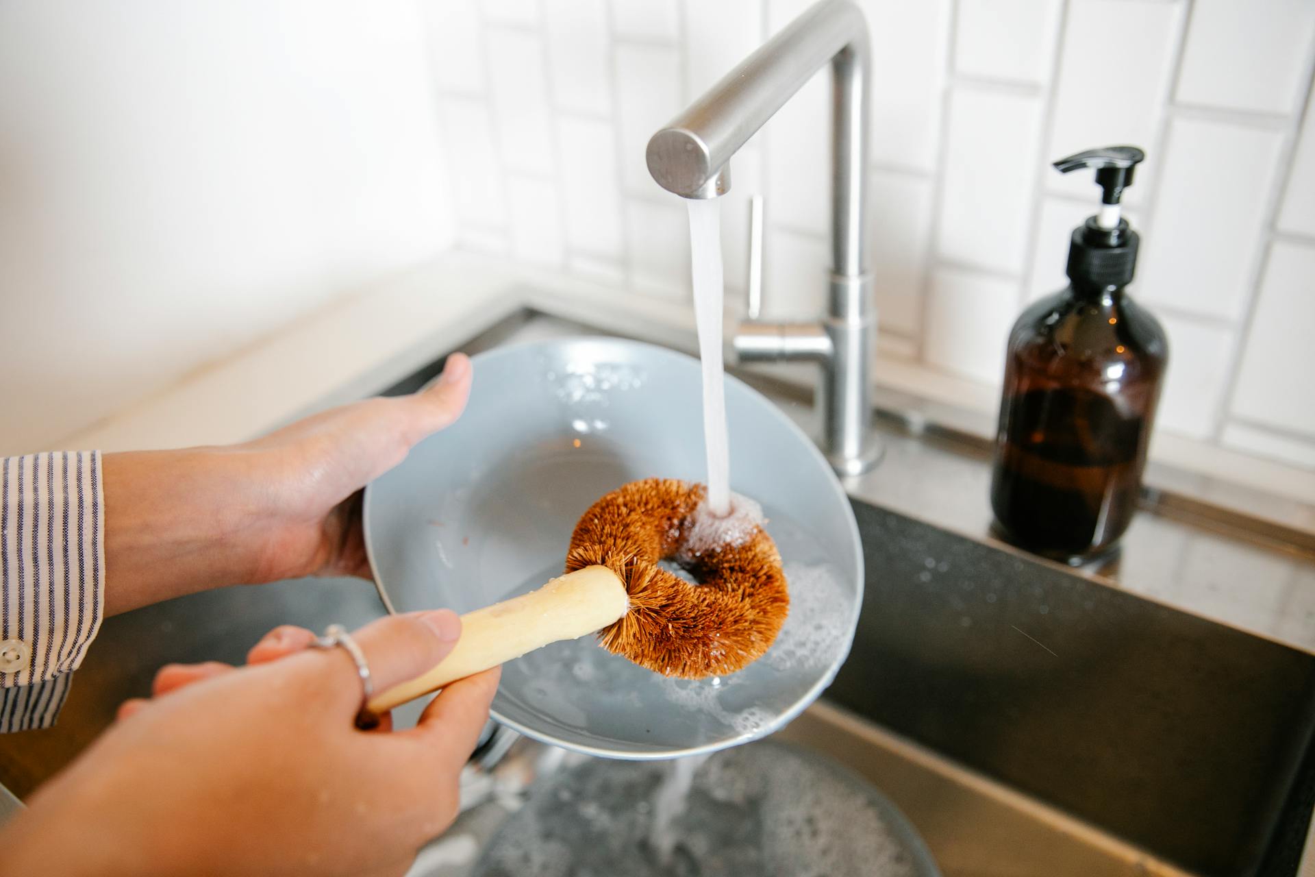 A close-up shot of a woman washing dishes in the kitchen | Source: Pexels
