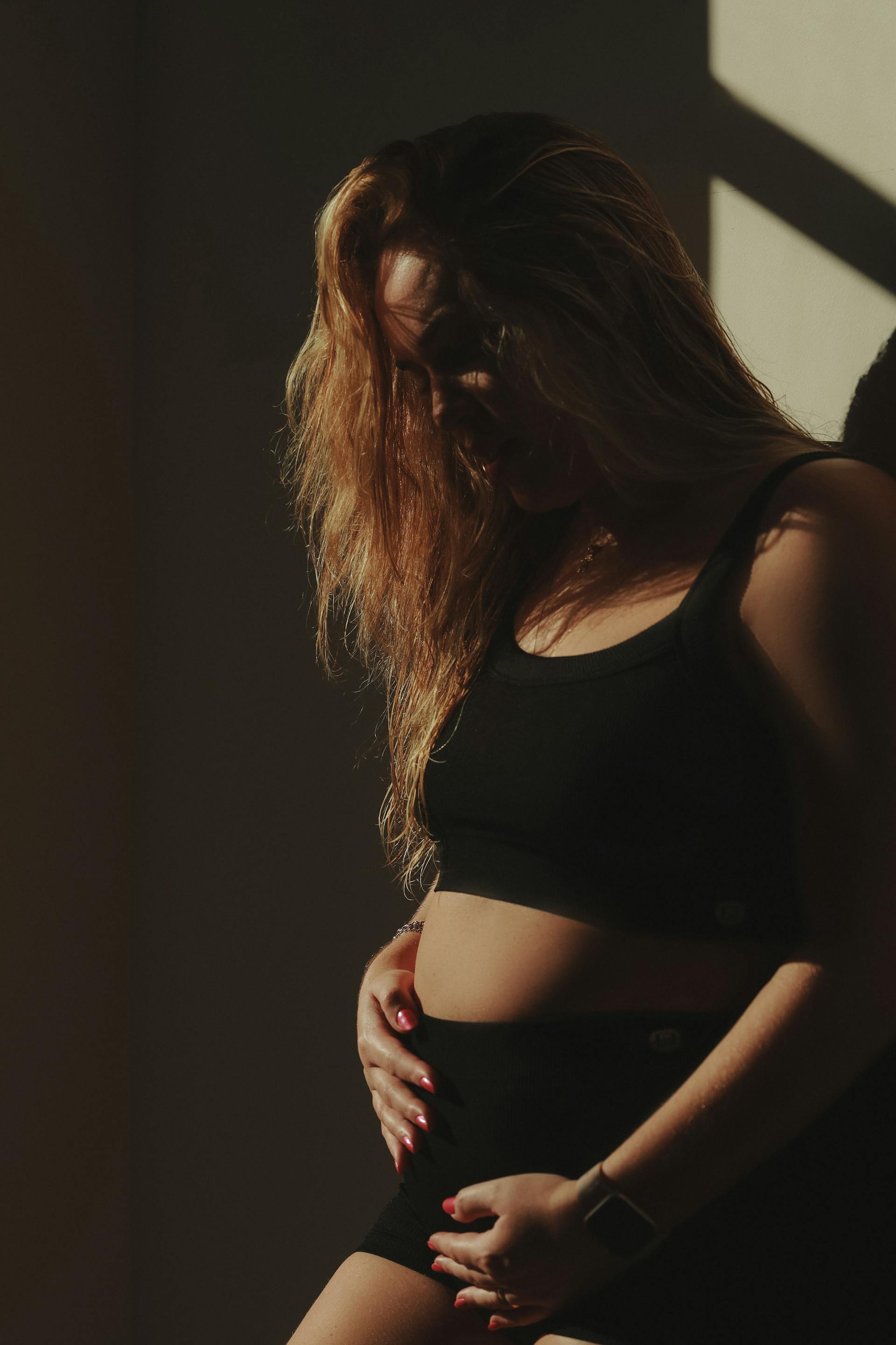 A pregnant woman touching her belly | Source: Pexels