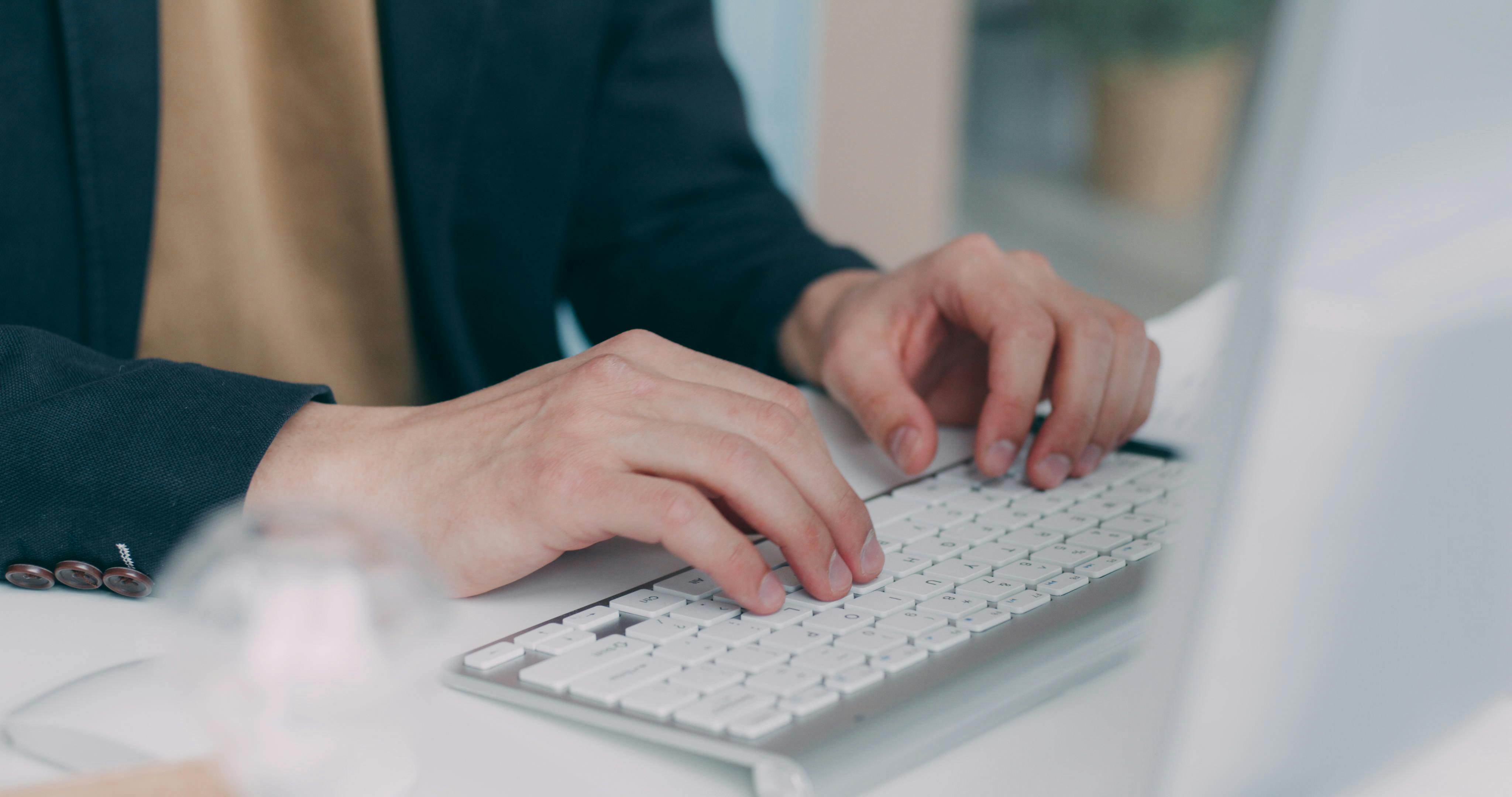 Hands typing on a computer keyboard | Source: Pexels
