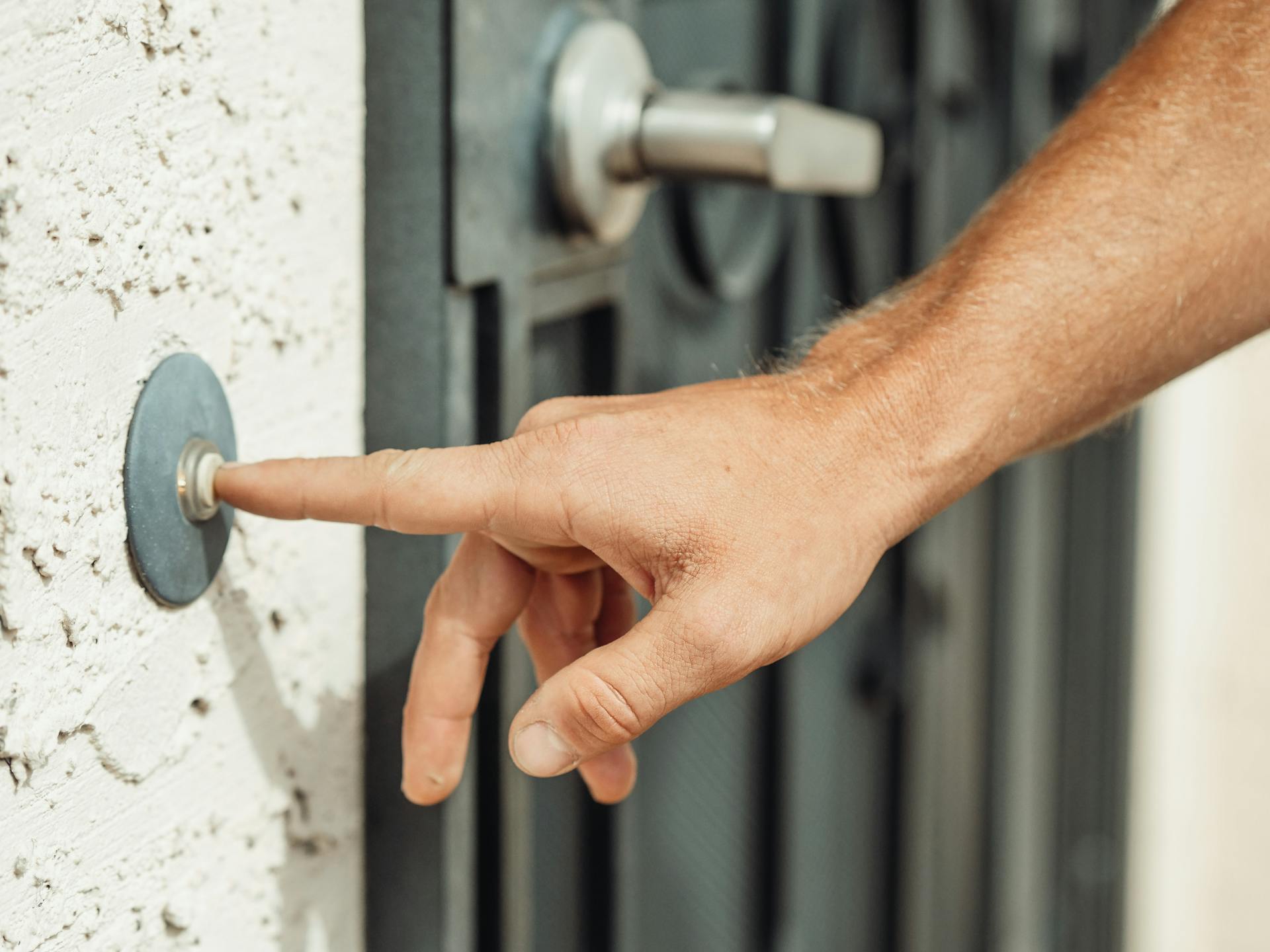 A person pressing a doorbell | Source: Pexels