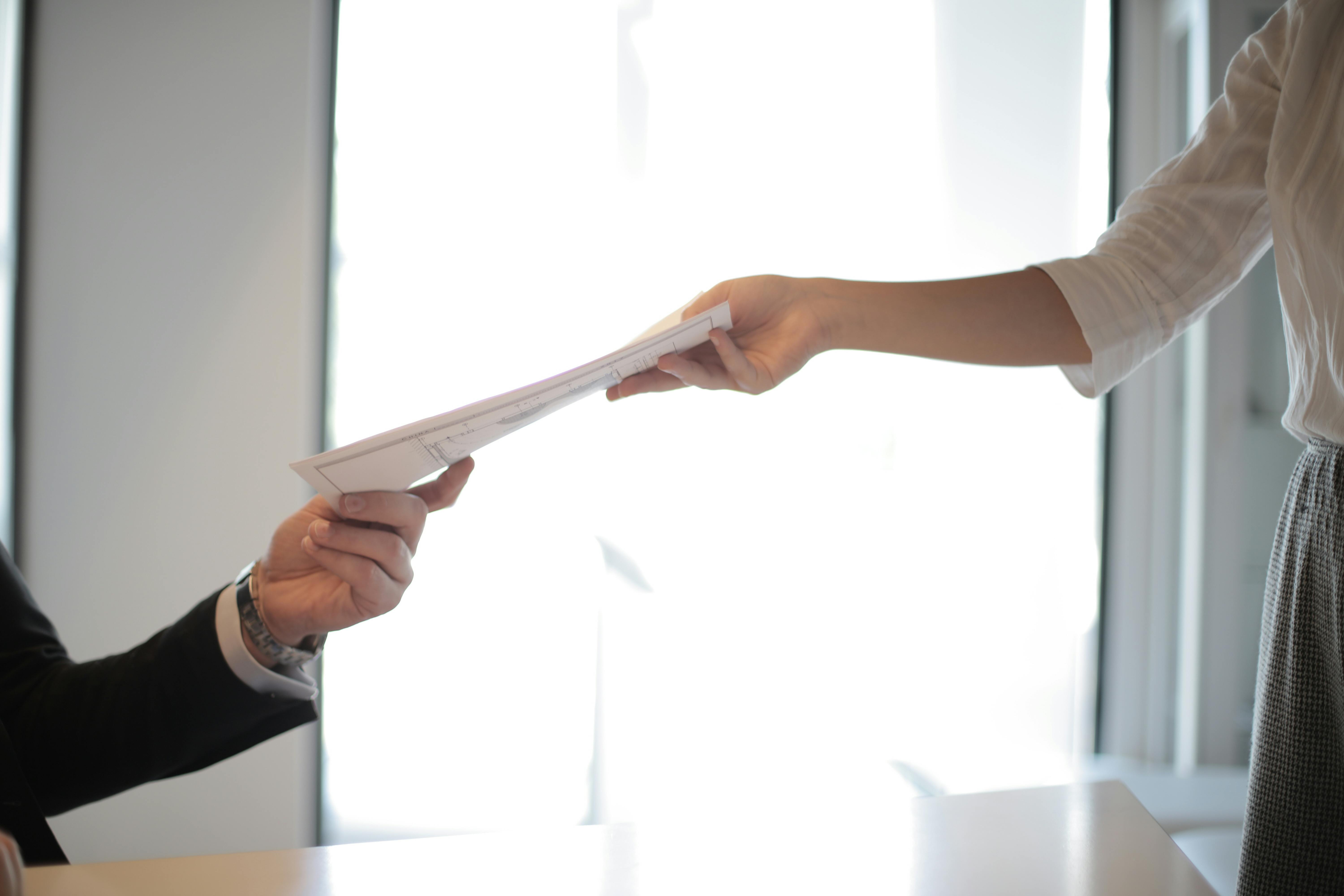 People exchanging documents | Source: Pexels