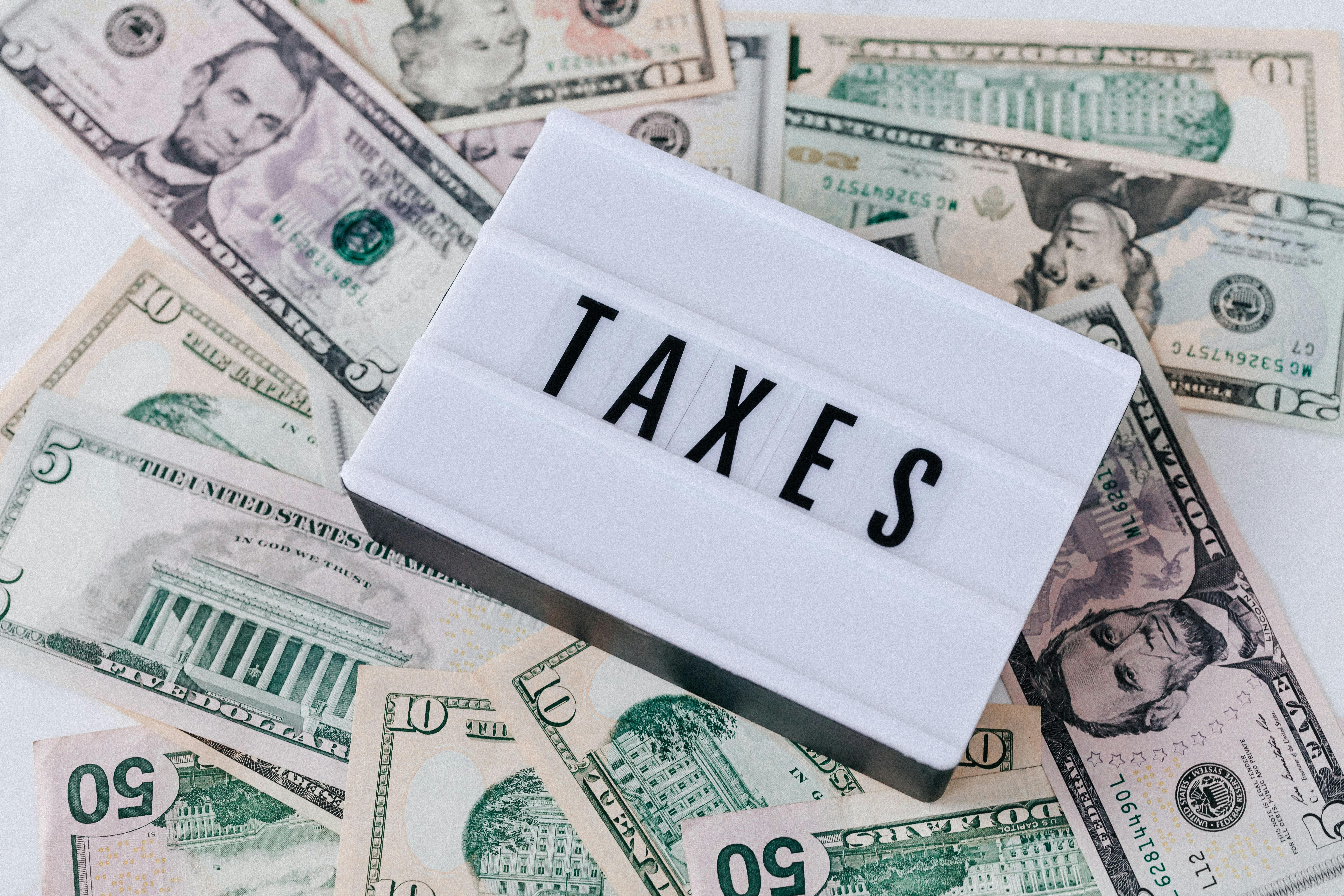 Quote board spelling "Taxes" on top of dollar bills | Source: Pexels
