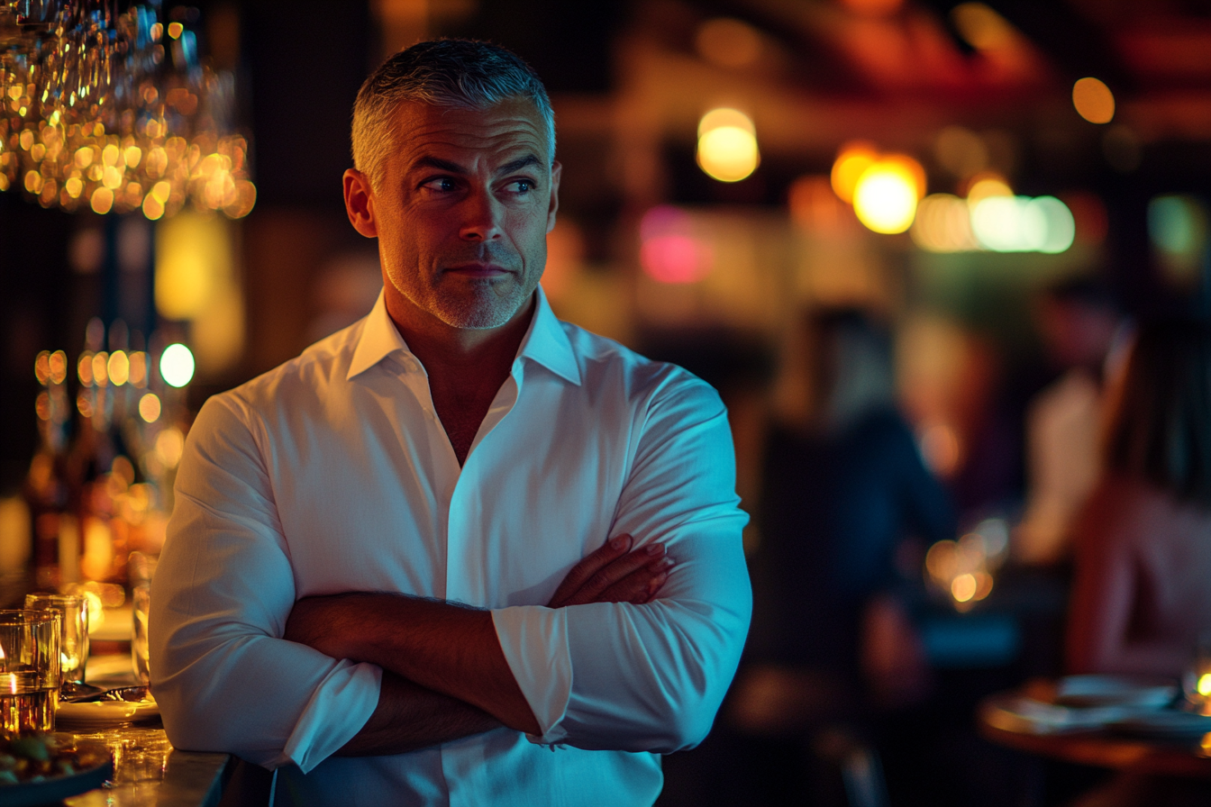 Restaurant manager smirking by the bar | Source: No source