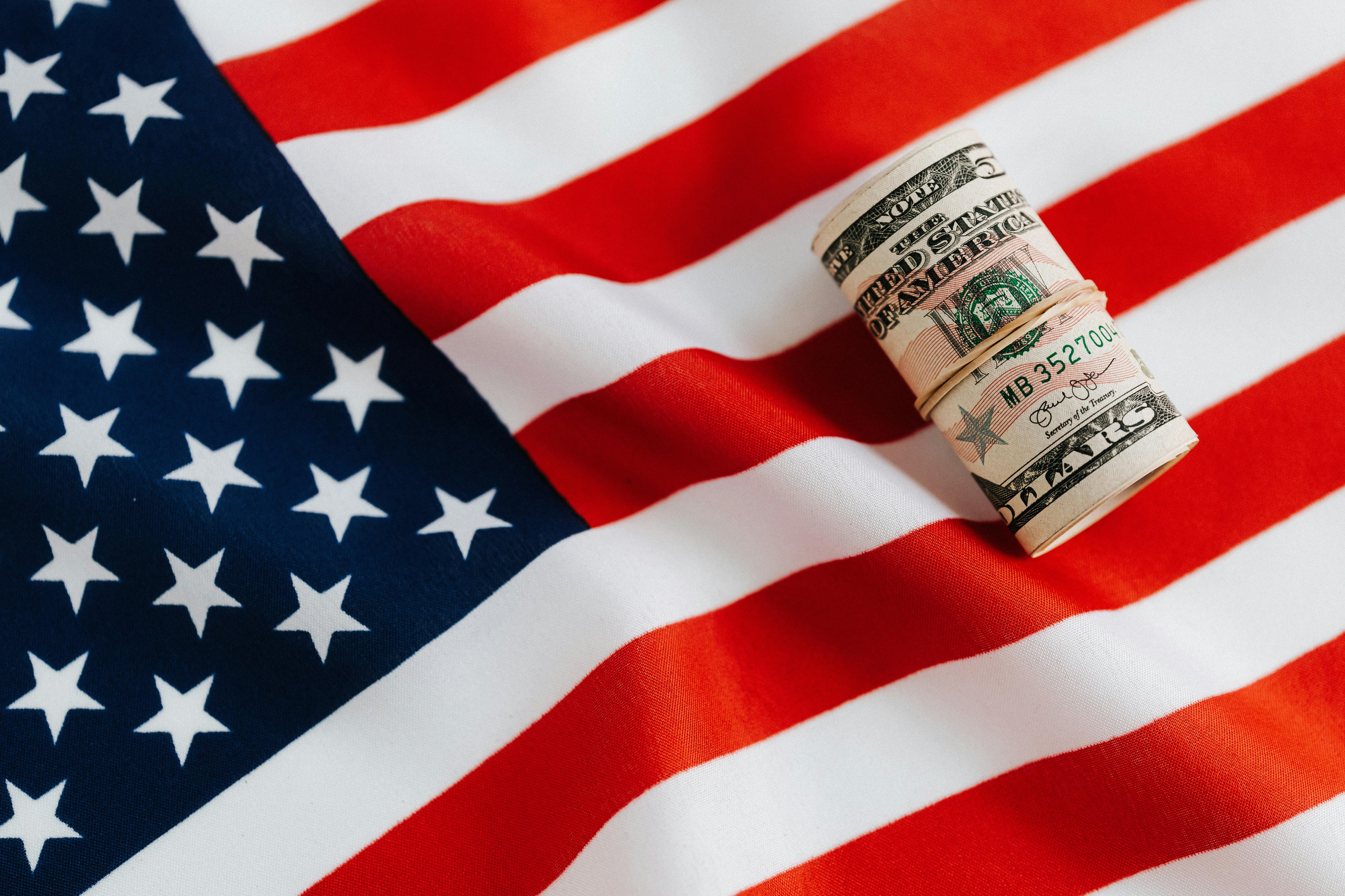 Dollar bills on American flag | Source: Pexels