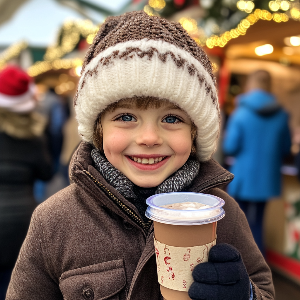 A happy boy holding hot chocolate | Source: No source