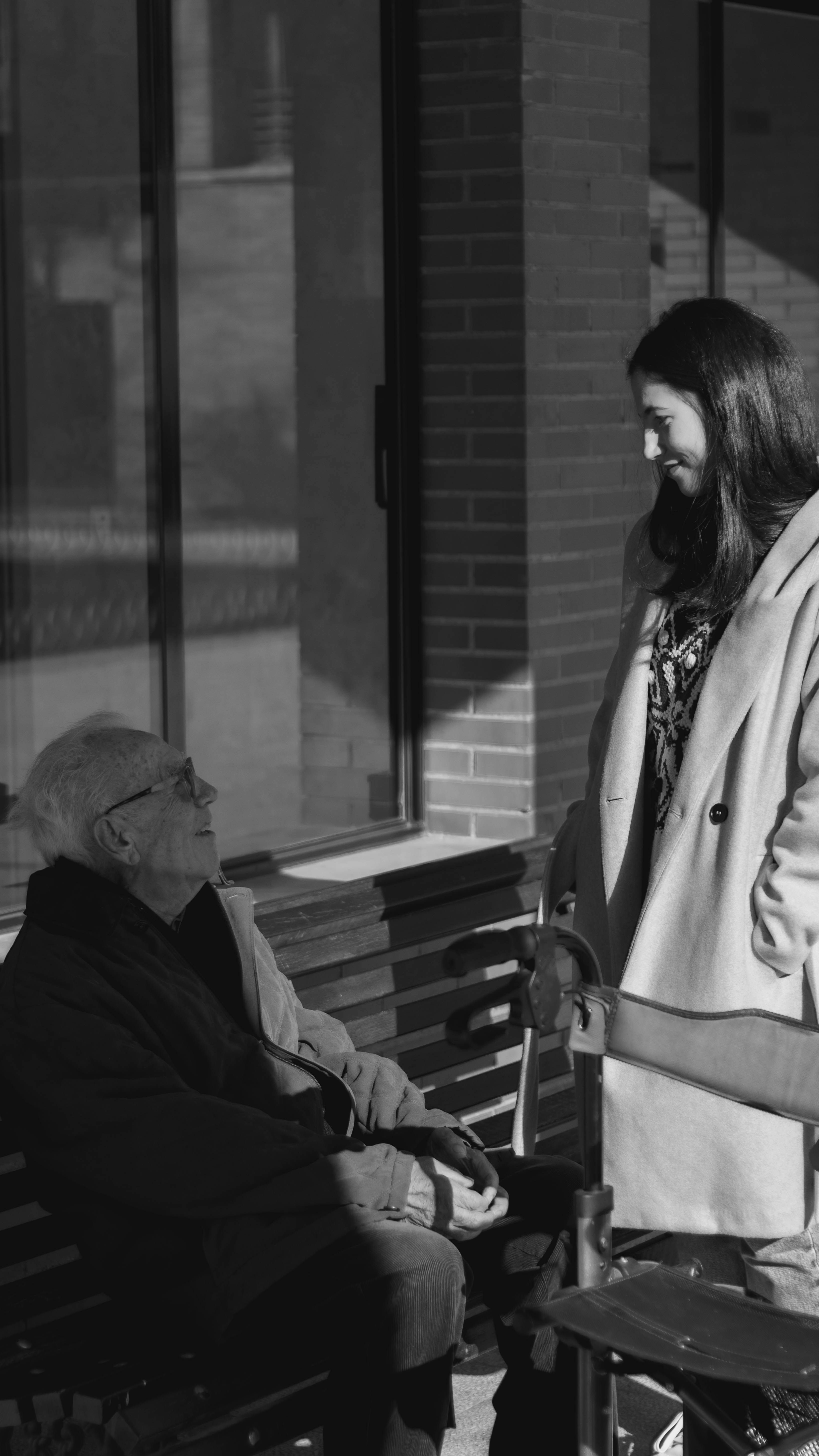 Elderly man sitting on a bench talking to a woman | Source: Unsplash
