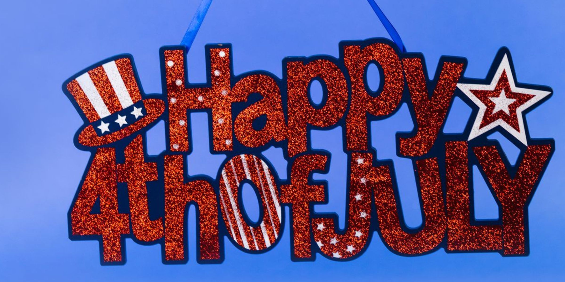 A glittery red, white, and blue "Happy 4th of July" sign with patriotic decorations | Source: Pexels