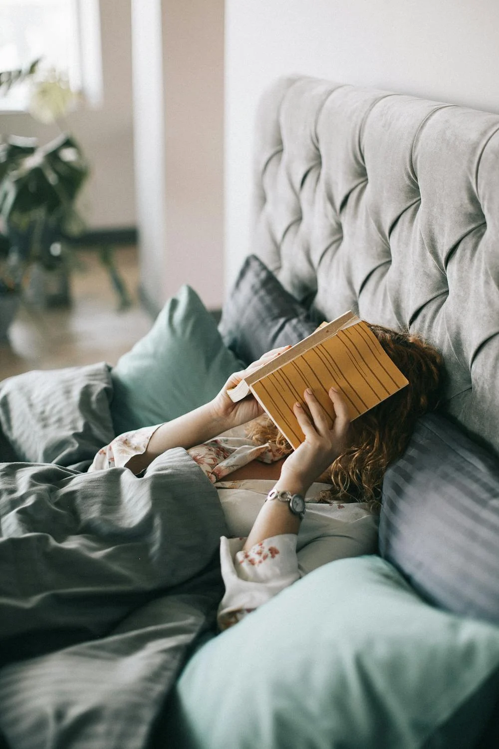 A woman in bed covering her face with her hands | Source: Pexels