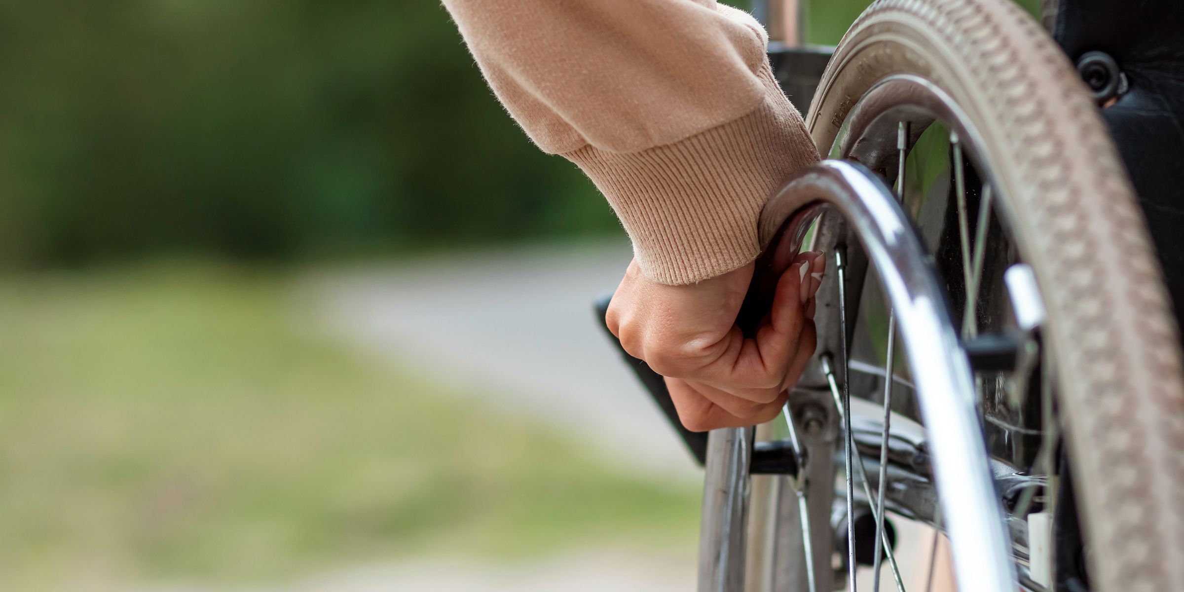 A hand gripping the wheel on a wheelchair | Source: Shutterstock