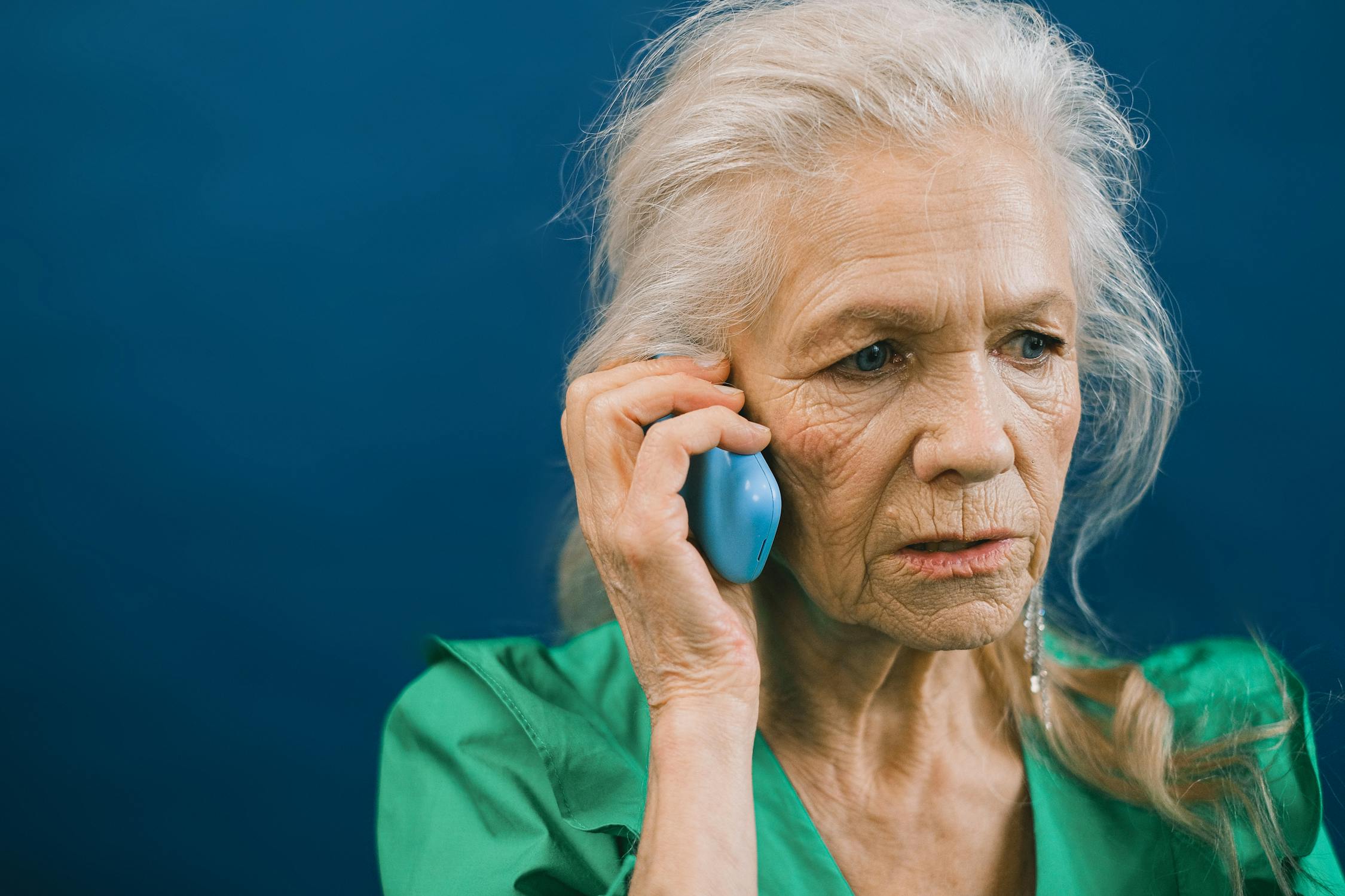 A concerned elderly woman talking on her phone | Source: Pexels