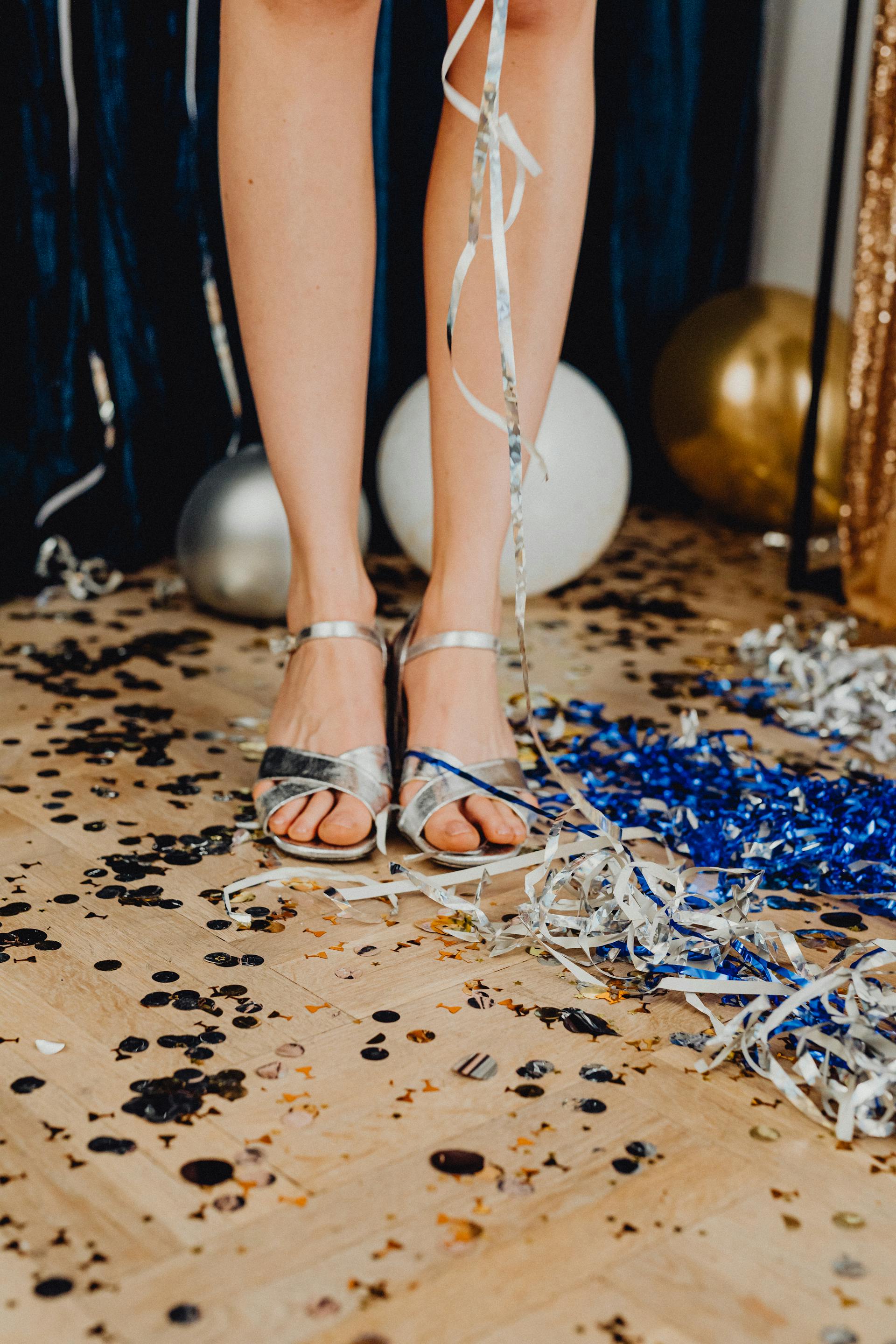 A woman standing on a floor littered with streamers and confetti | Source: Pexels