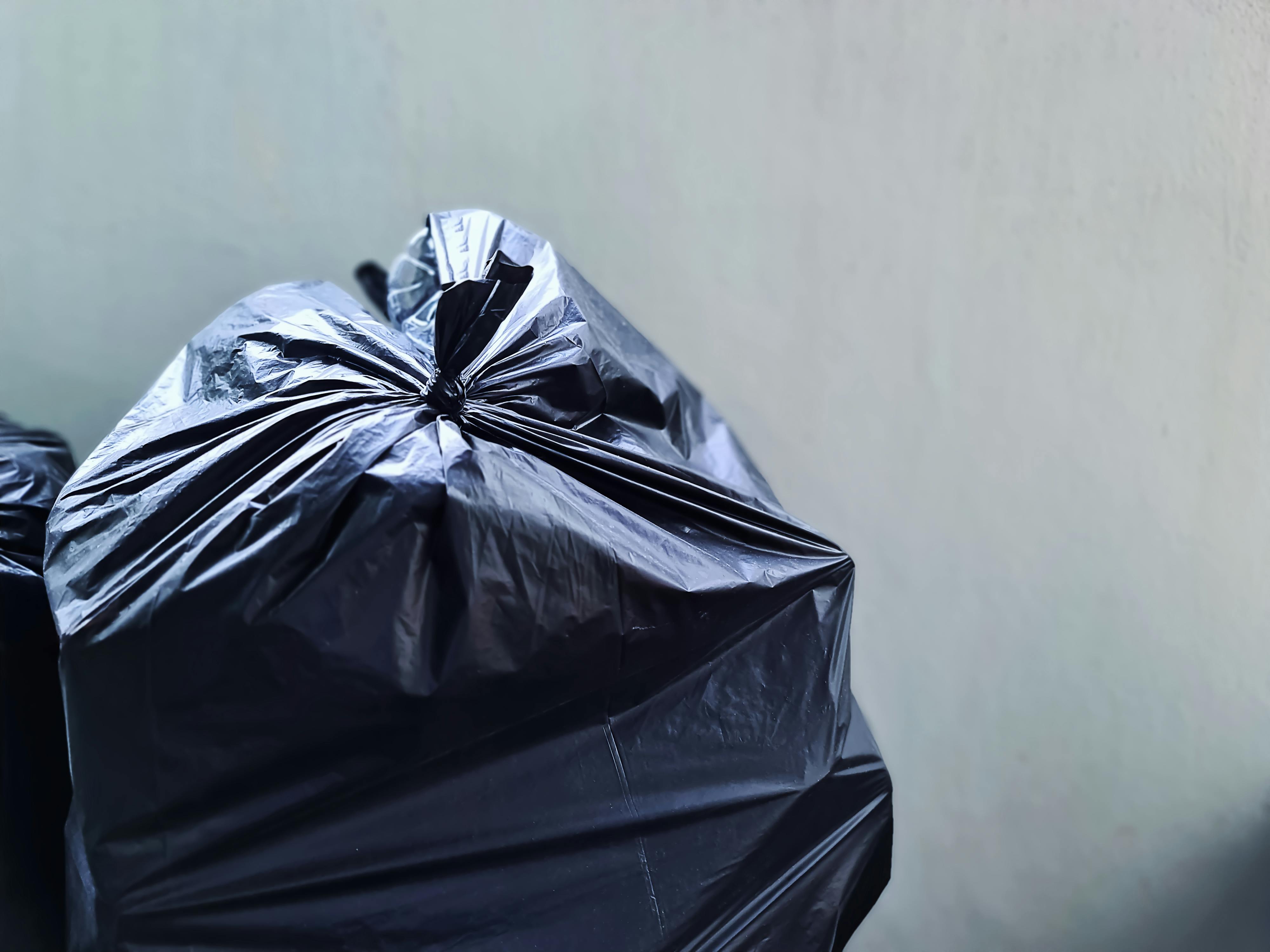 Black plastic bag near concrete wall | Source: Pexels