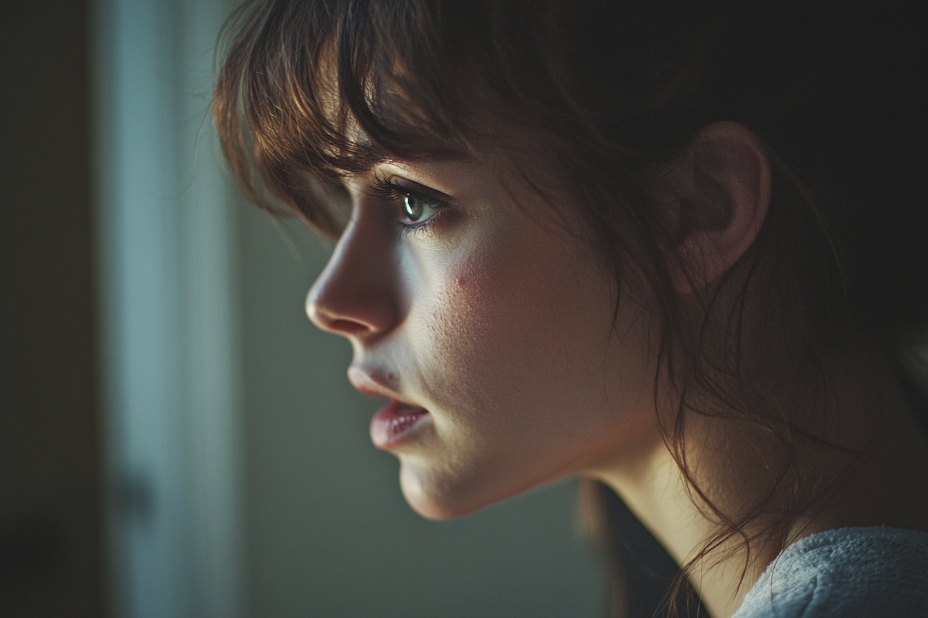 A woman looking out a window | Source: no source